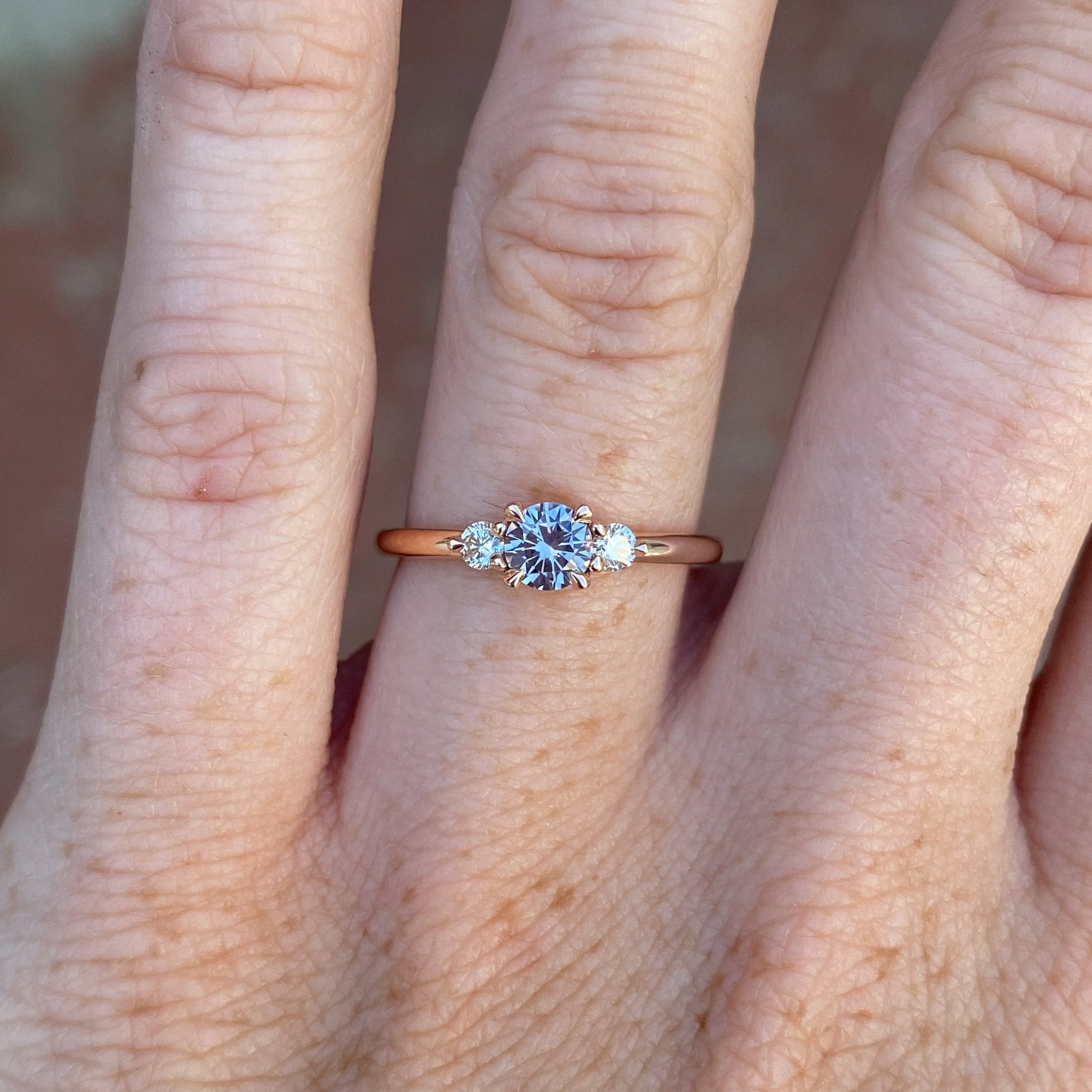 0.40ct Montana sapphire lunar trilogy engagement ring on hand