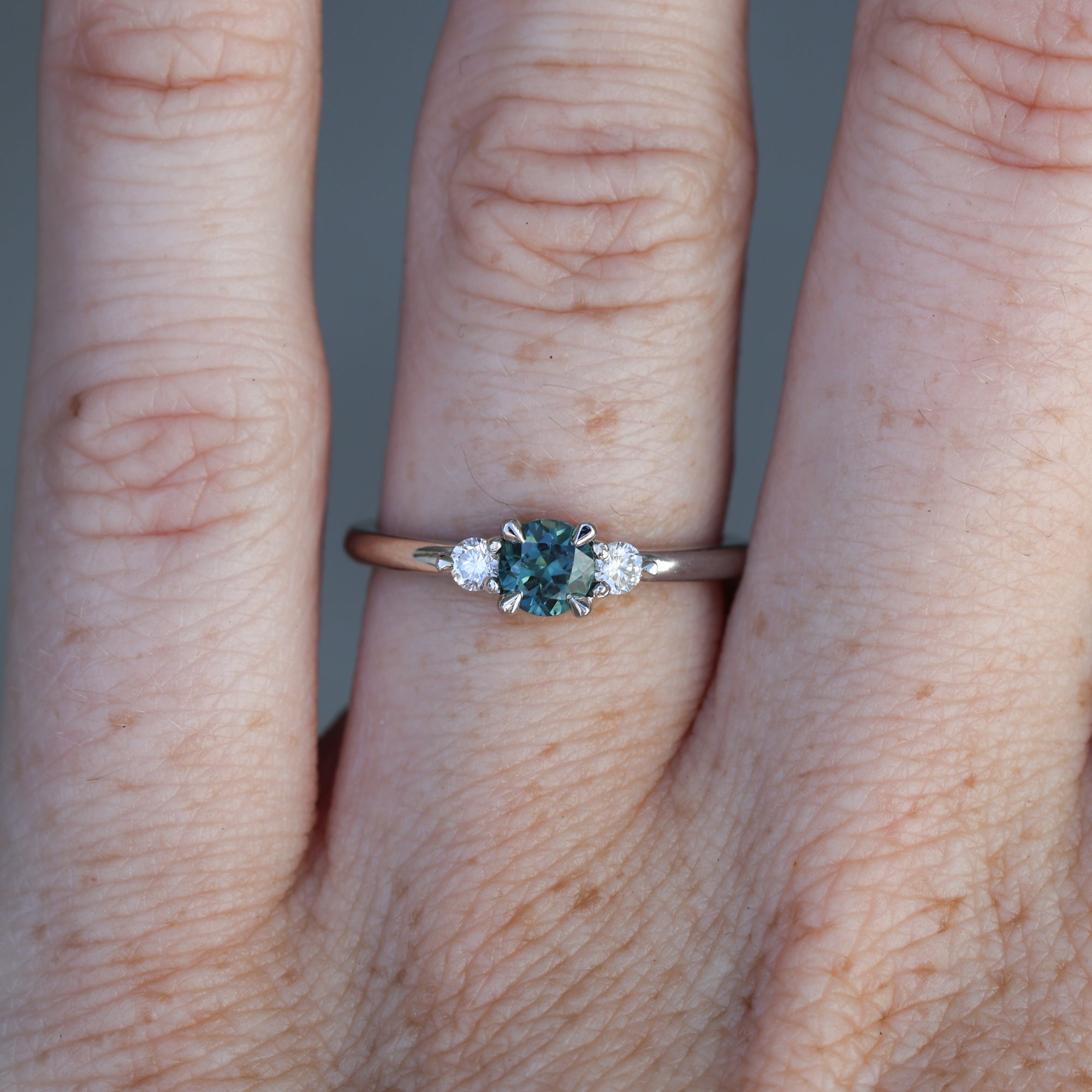 0.46ct round cut australian parti sapphire trilogy engagement ring on hand