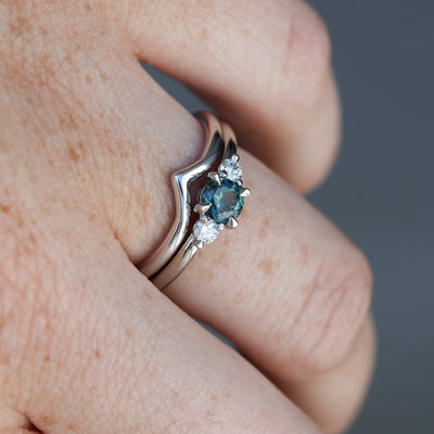 0.46ct round cut australian parti sapphire trilogy engagement ring on hand with wedding band