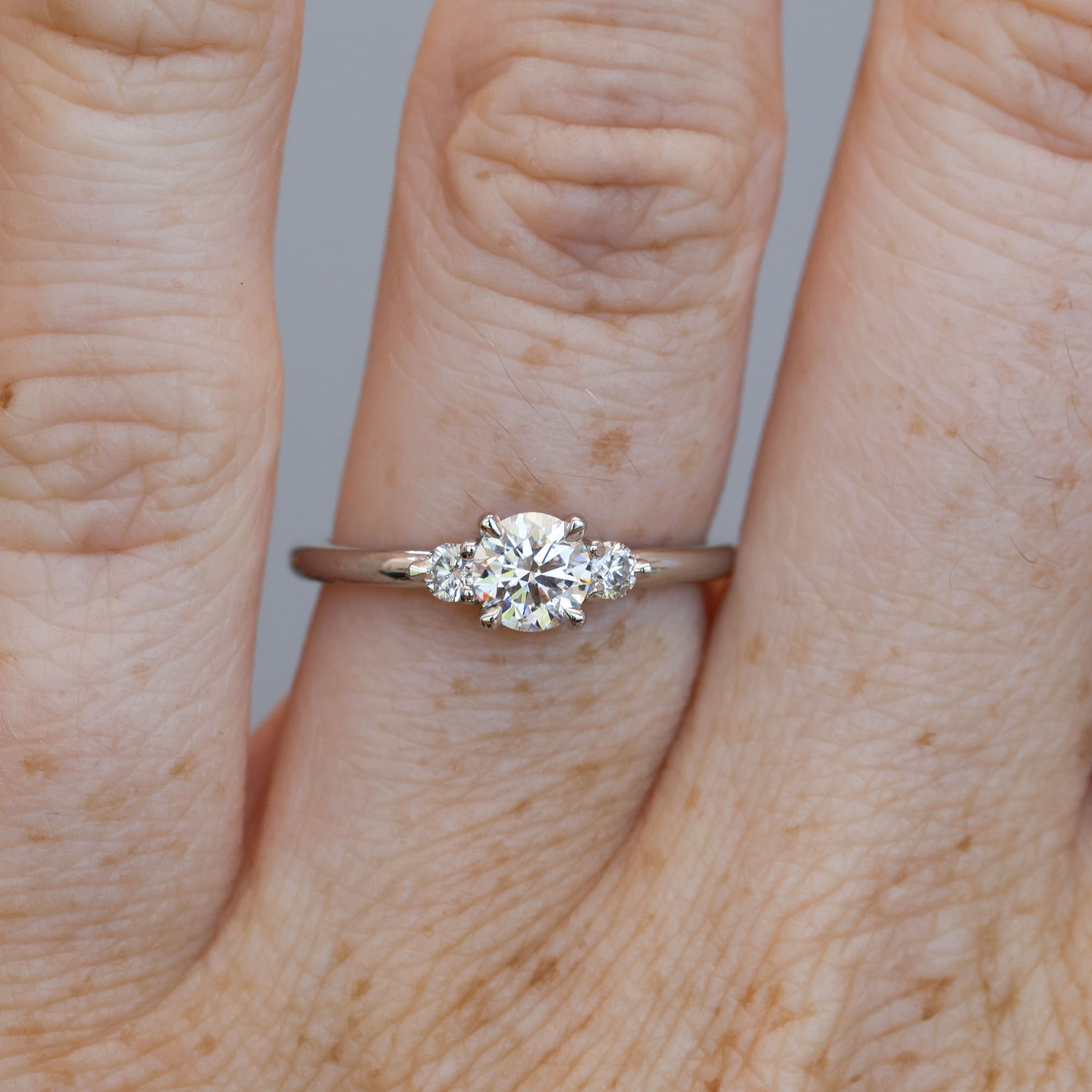 0.50ct round cut lunar trilogy engagement ring in platinum on hand