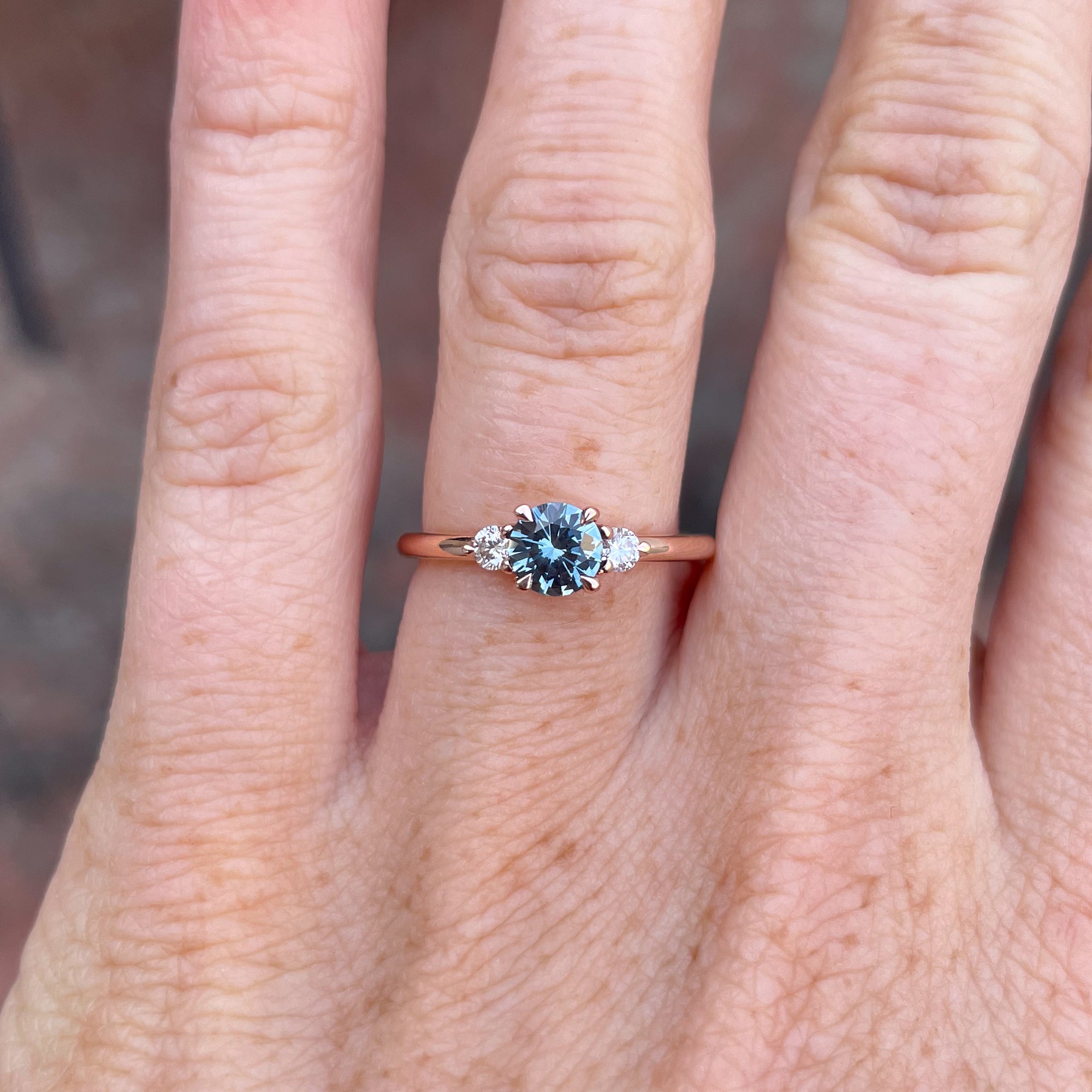 0.58ct Montana Sapphire trilogy engagement ring on hand