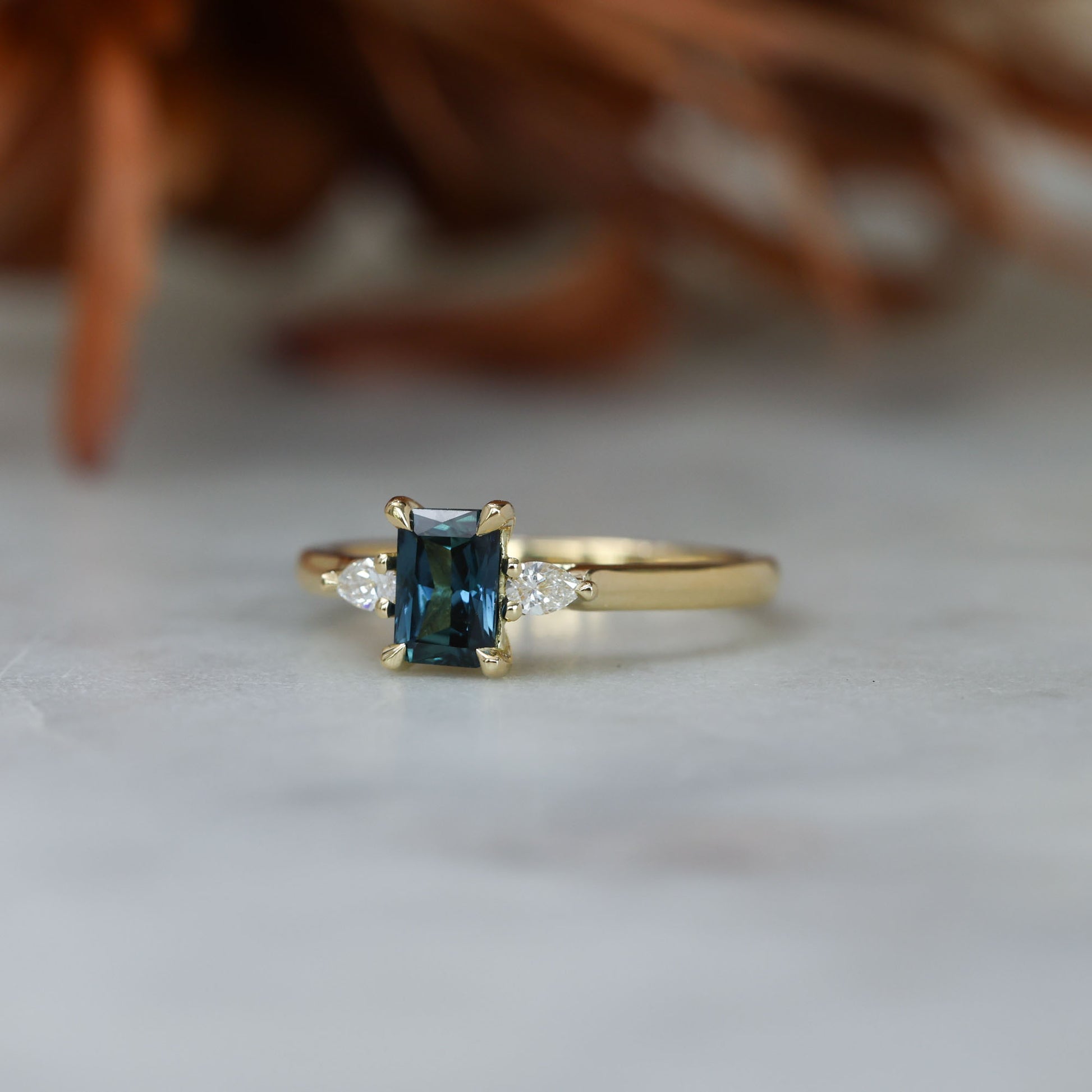 0.66ct Emerald cut australian sapphire trilogy engagement ring front side