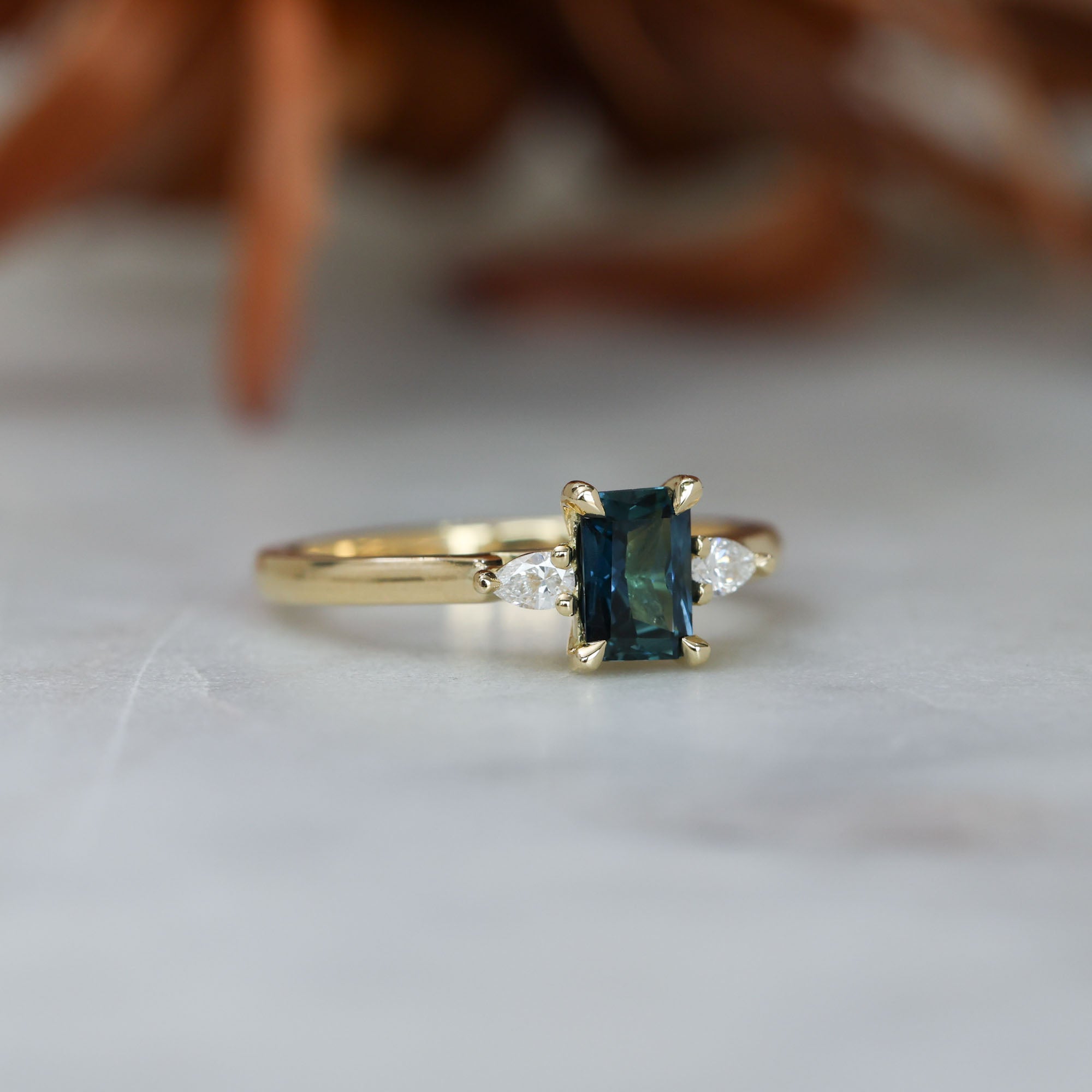 0.66ct Emerald cut australian sapphire trilogy engagement ring side