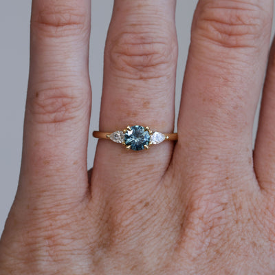 0.67ct Montana Sapphire and diamond May trilogy engagement ring on hand