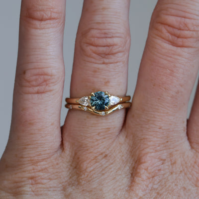 0.67ct Montana Sapphire and diamond May trilogy engagement ring on hand with wedding band