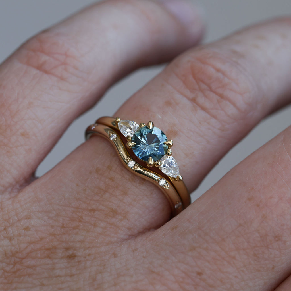 0.67ct Montana Sapphire and diamond May trilogy engagement ring on hand