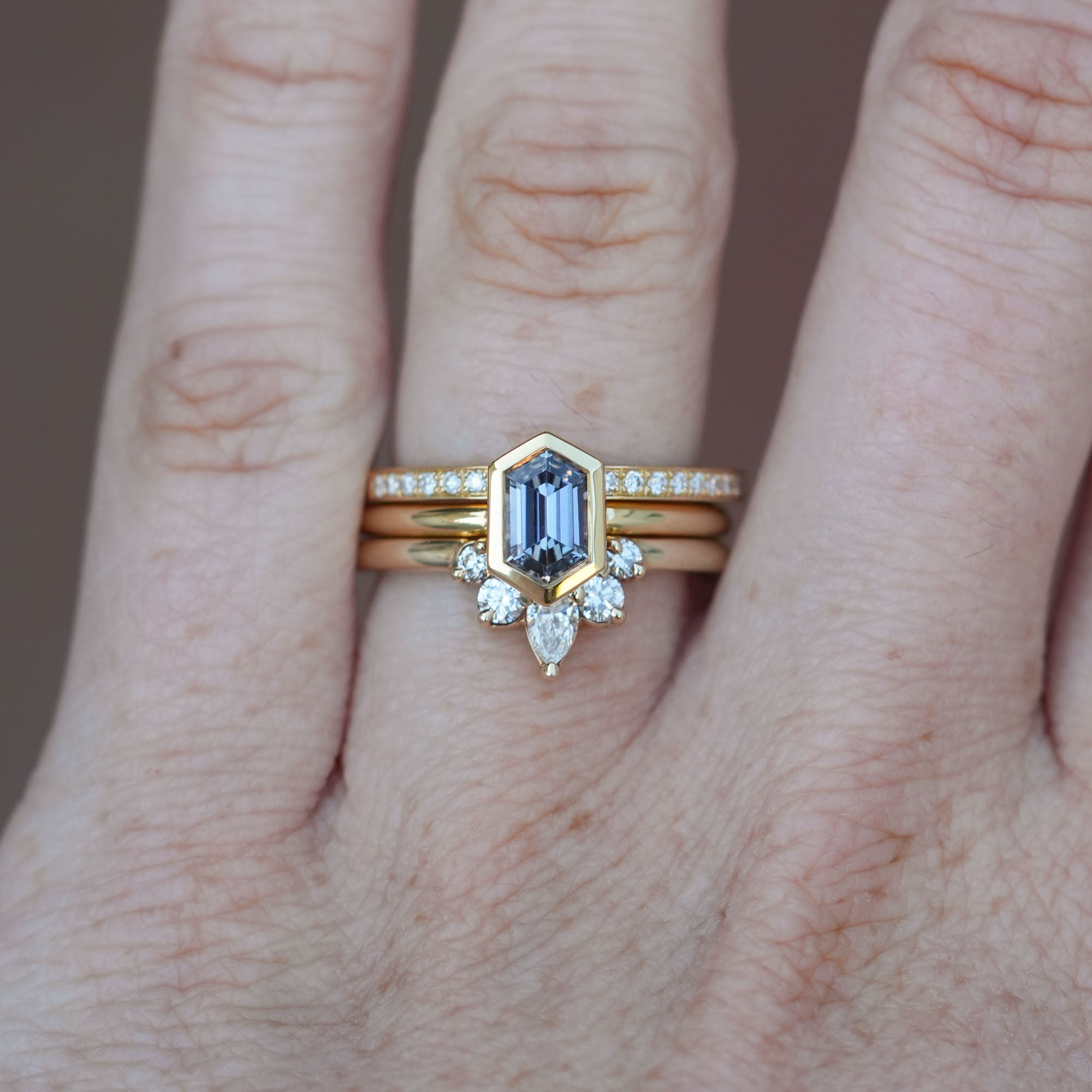 0.80ct Elongated Hexagon Ceylon Sapphire engagement ring on hand with wedding bands