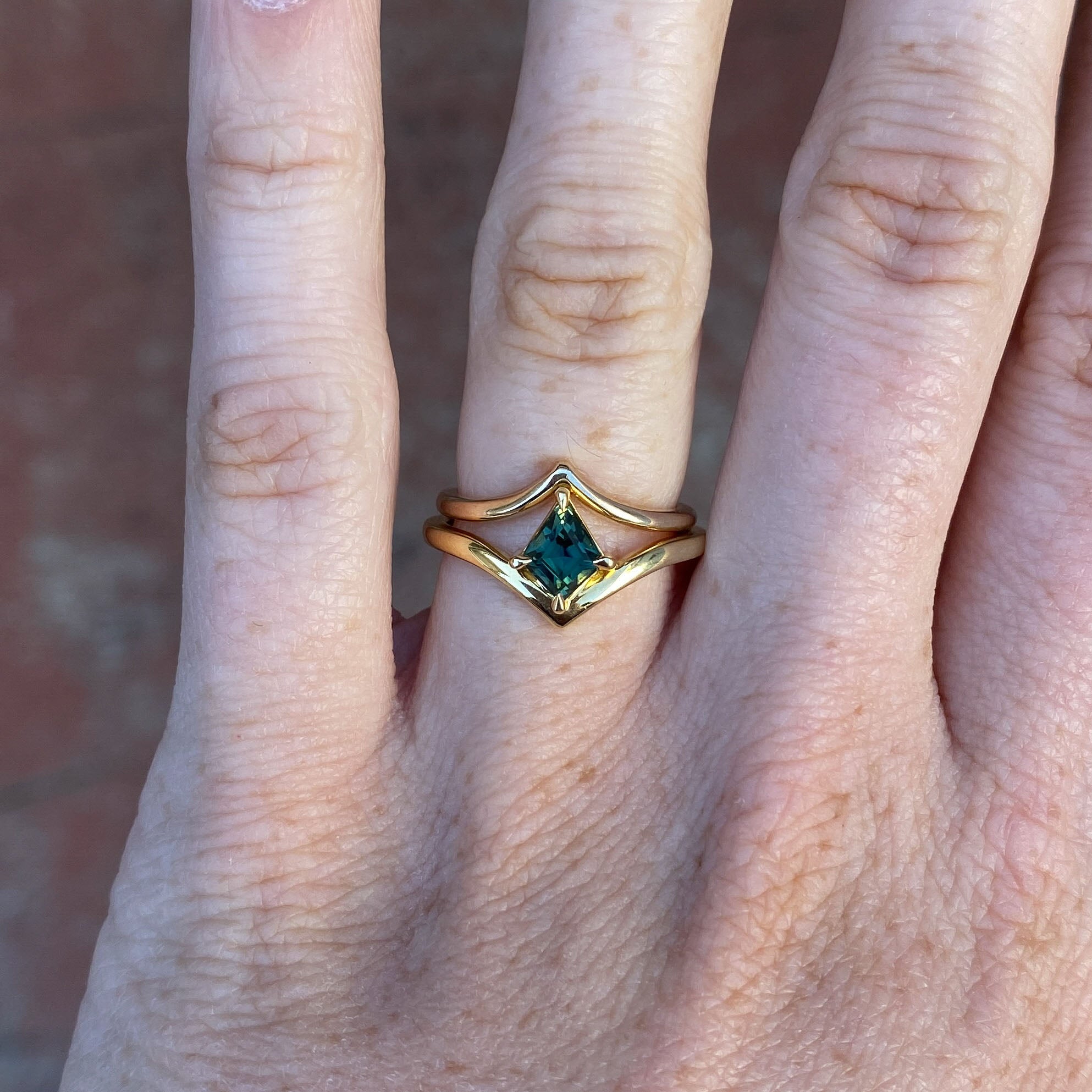 0.80ct Kite cut australian parti sapphire engagement ring on hand with wedding band