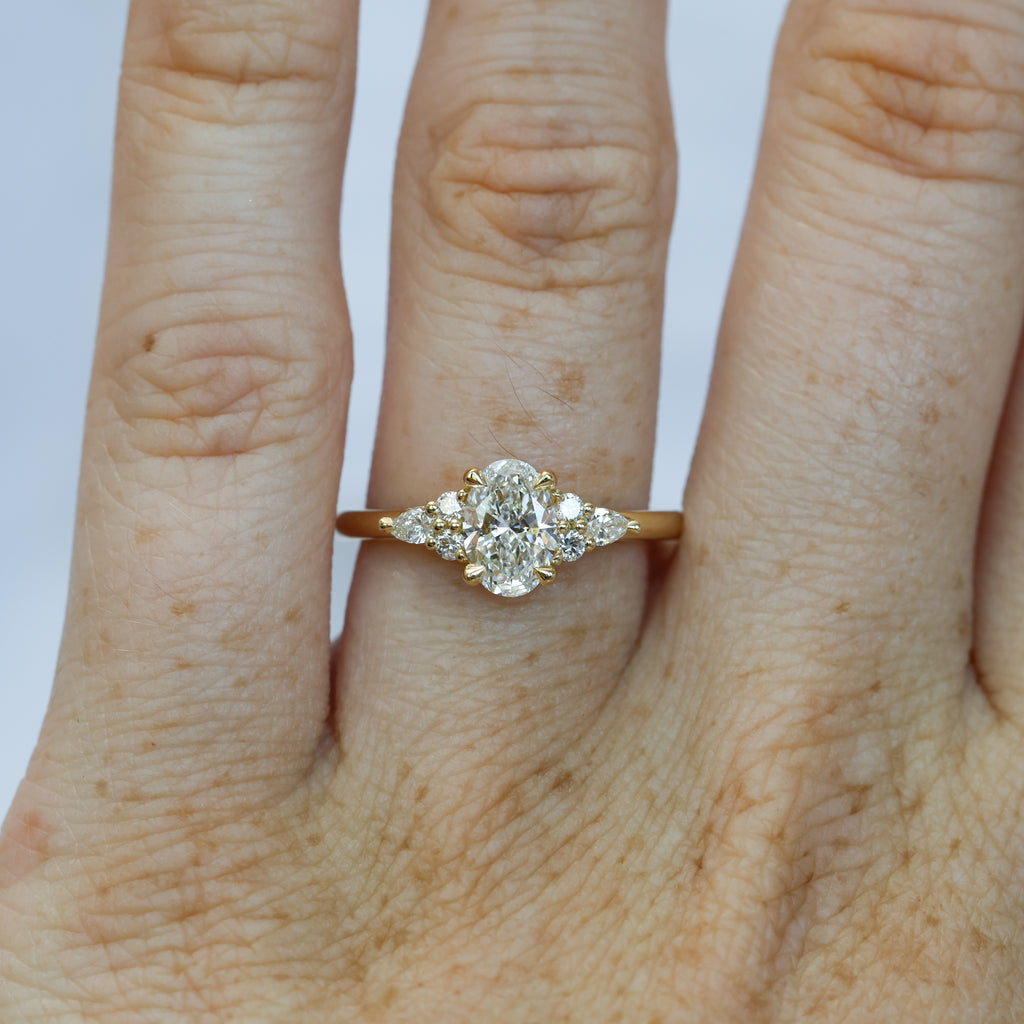 0.81ct oval cut diamond engagement ring with 6 side diamond on hand