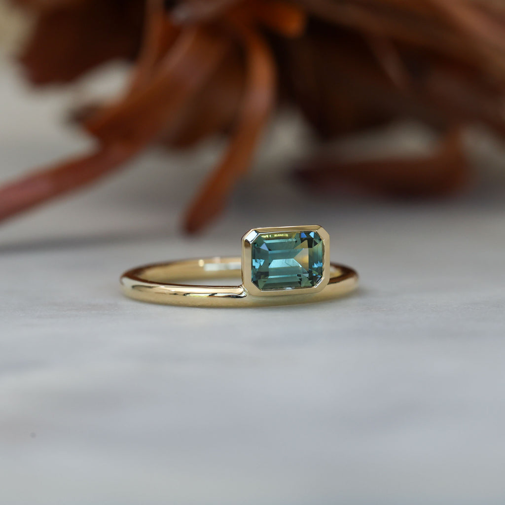 0.84ct emerald cut australian parti sapphire offset bezel engagement ring