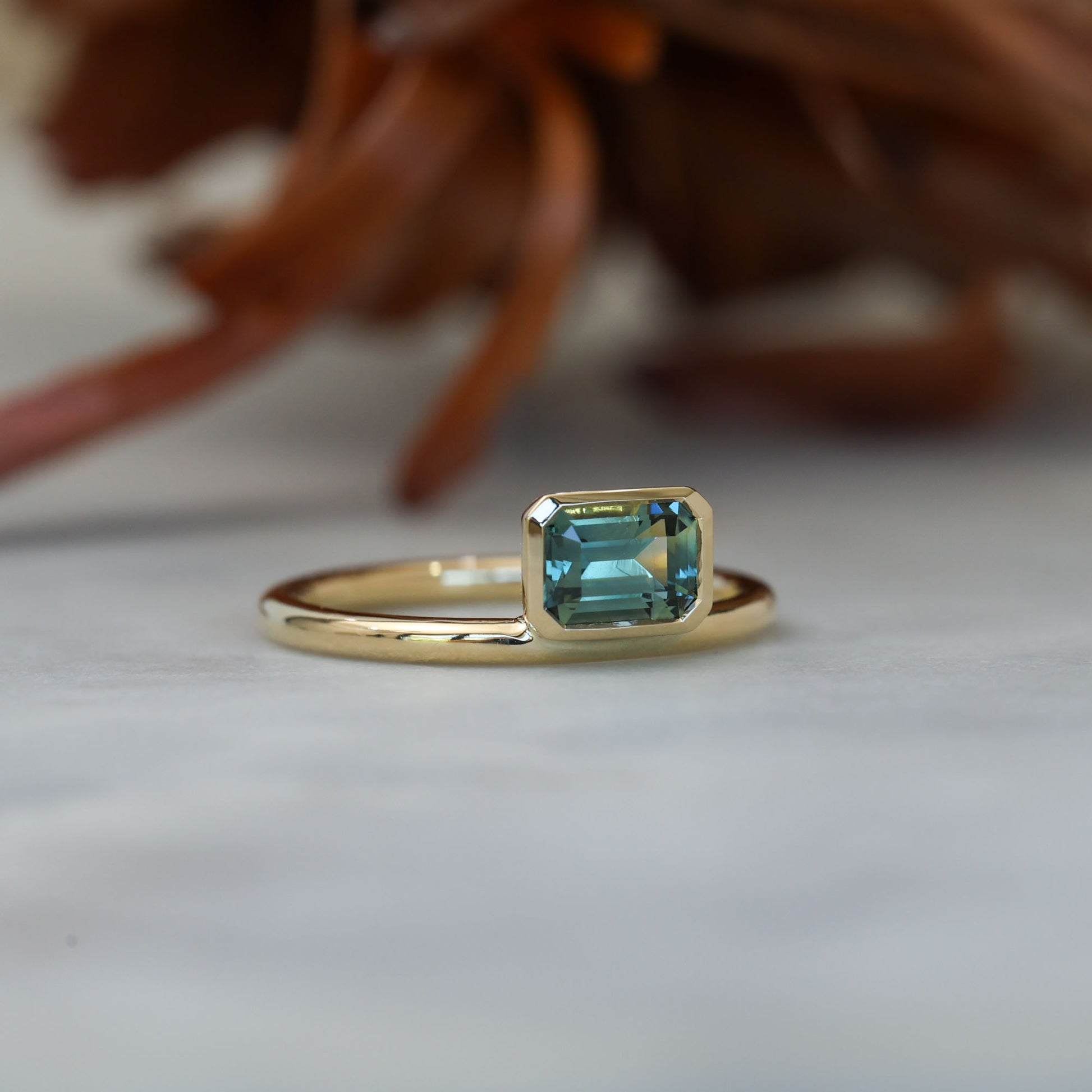 0.84ct emerald cut australian parti sapphire offset bezel engagement ring