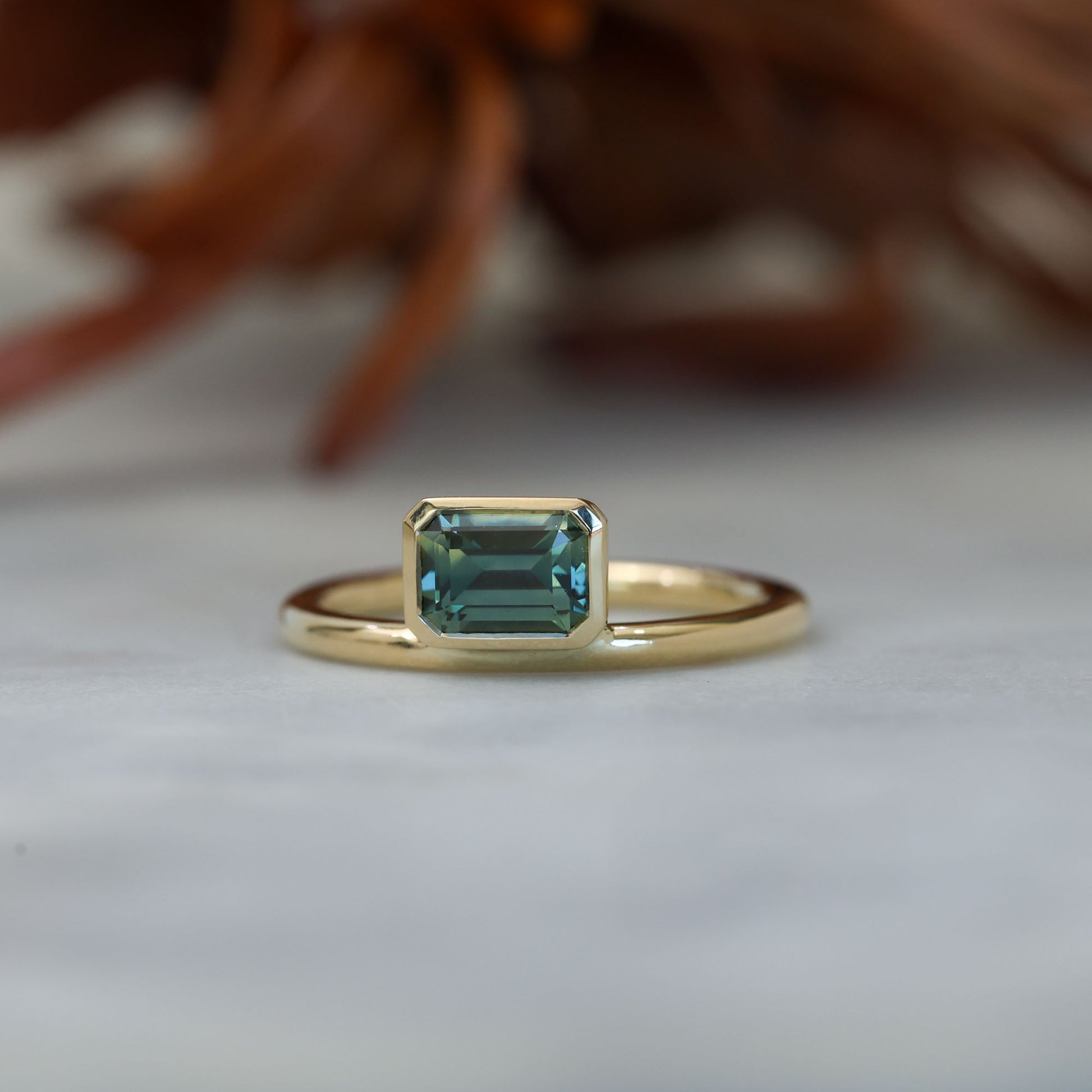 0.84ct emerald cut australian parti sapphire offset bezel engagement ring