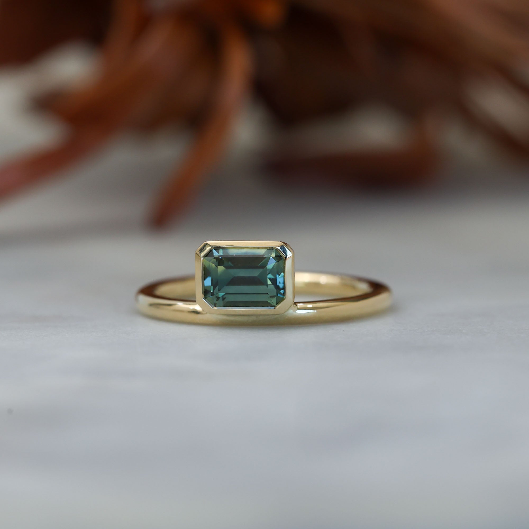 0.84ct emerald cut australian parti sapphire offset bezel engagement ring