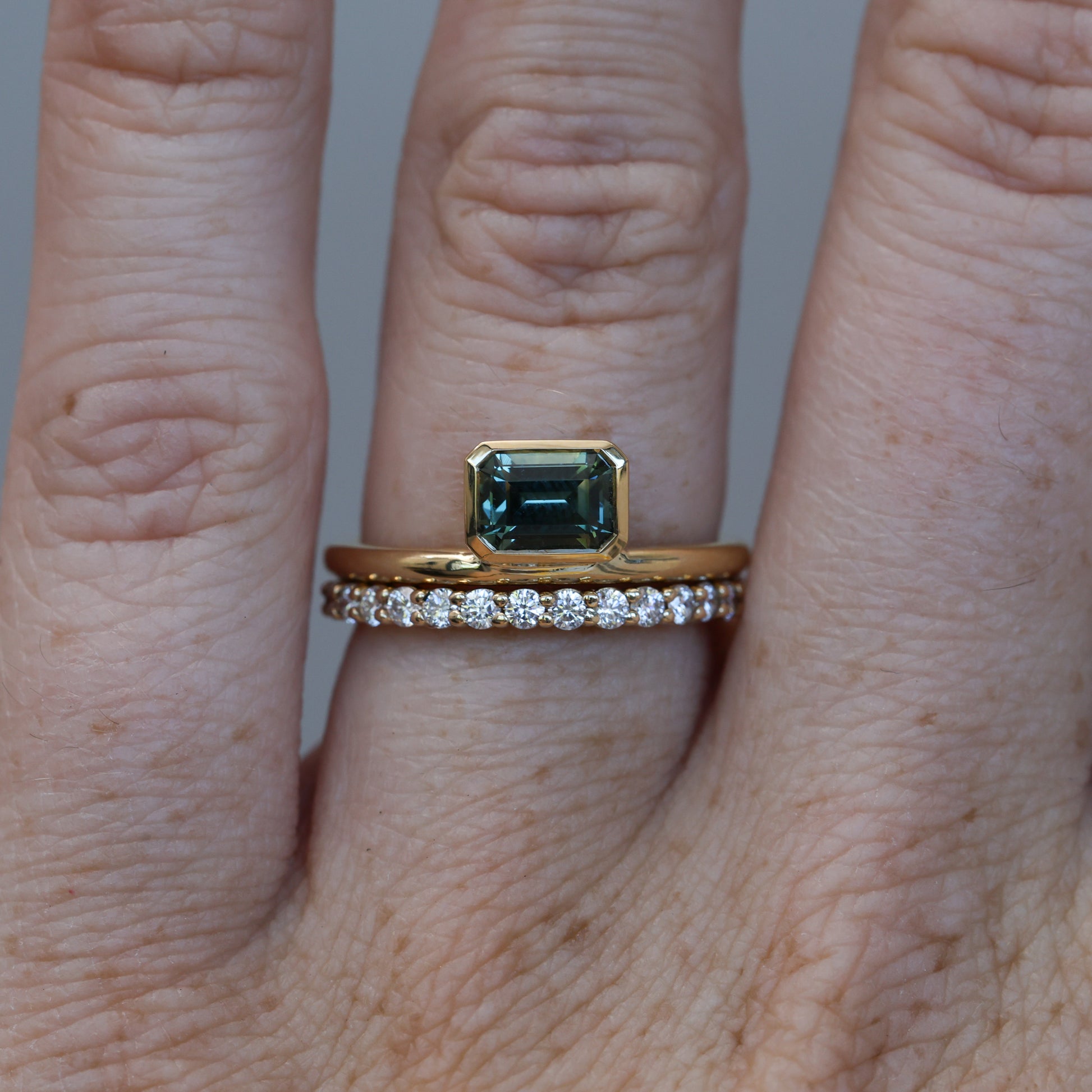 0.84ct emerald cut australian parti sapphire offset bezel engagement ring with diamond wedding band