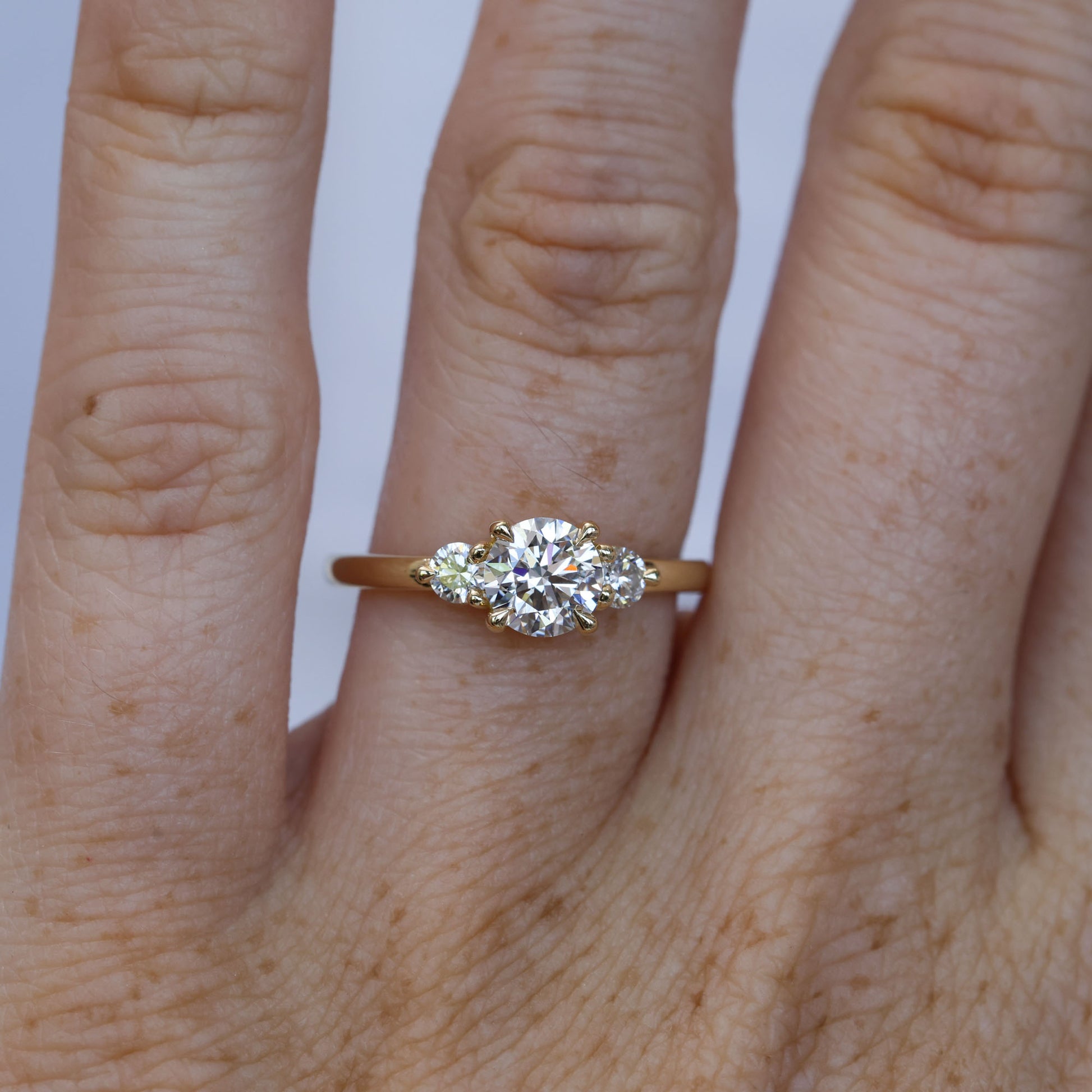 0.84ct round cut diamond trilogy engagement ring  on hand 