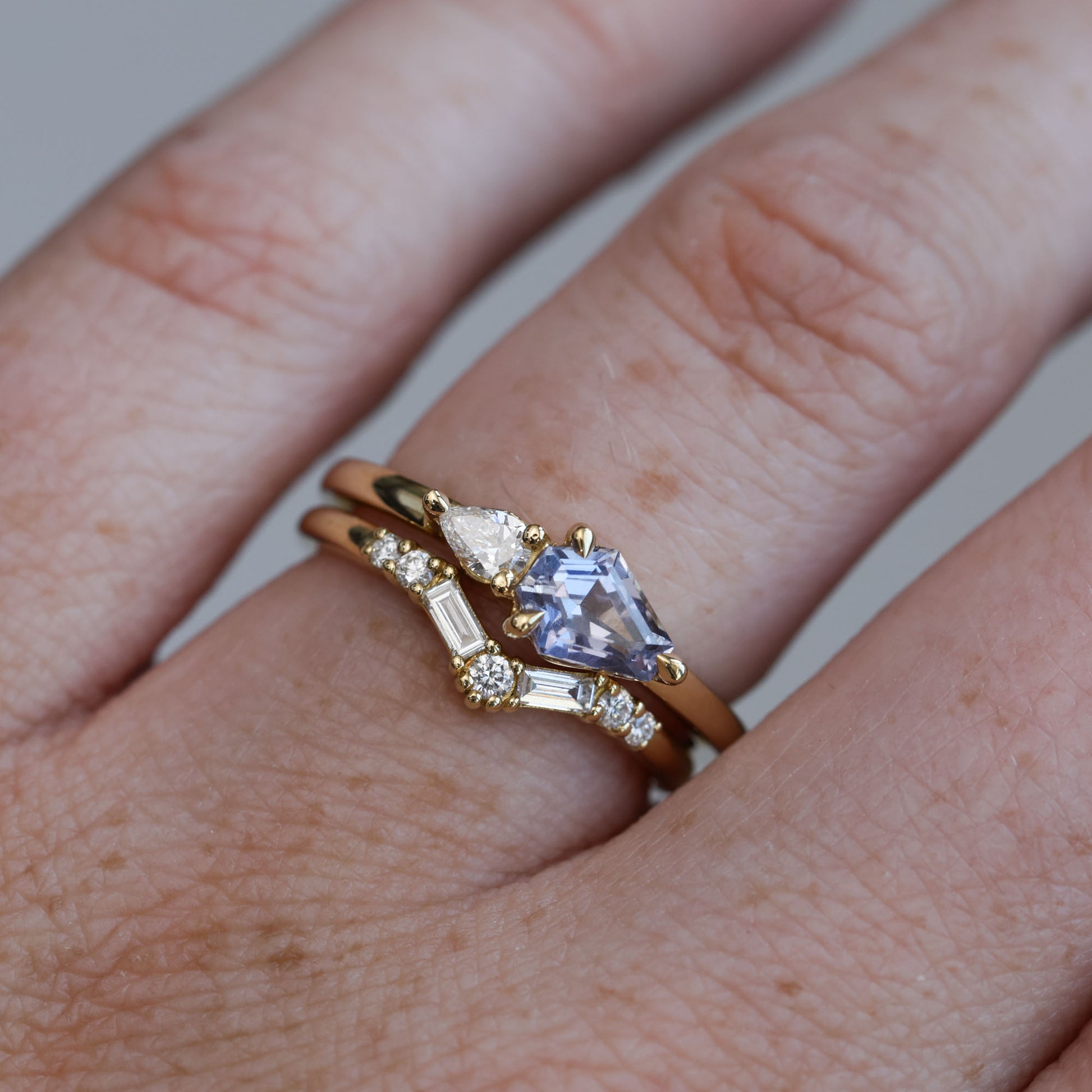 0.85ct Madagascan Sapphire & diamond engagement ring on hand with wedding band