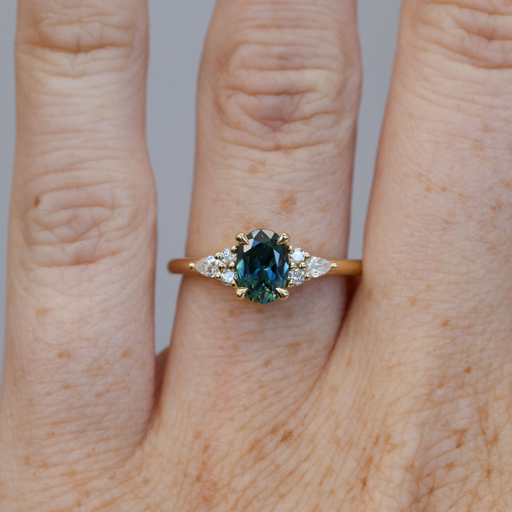 0.93ct oval cut Australian Sapphire and diamond engagement ring in yellow gold on hand