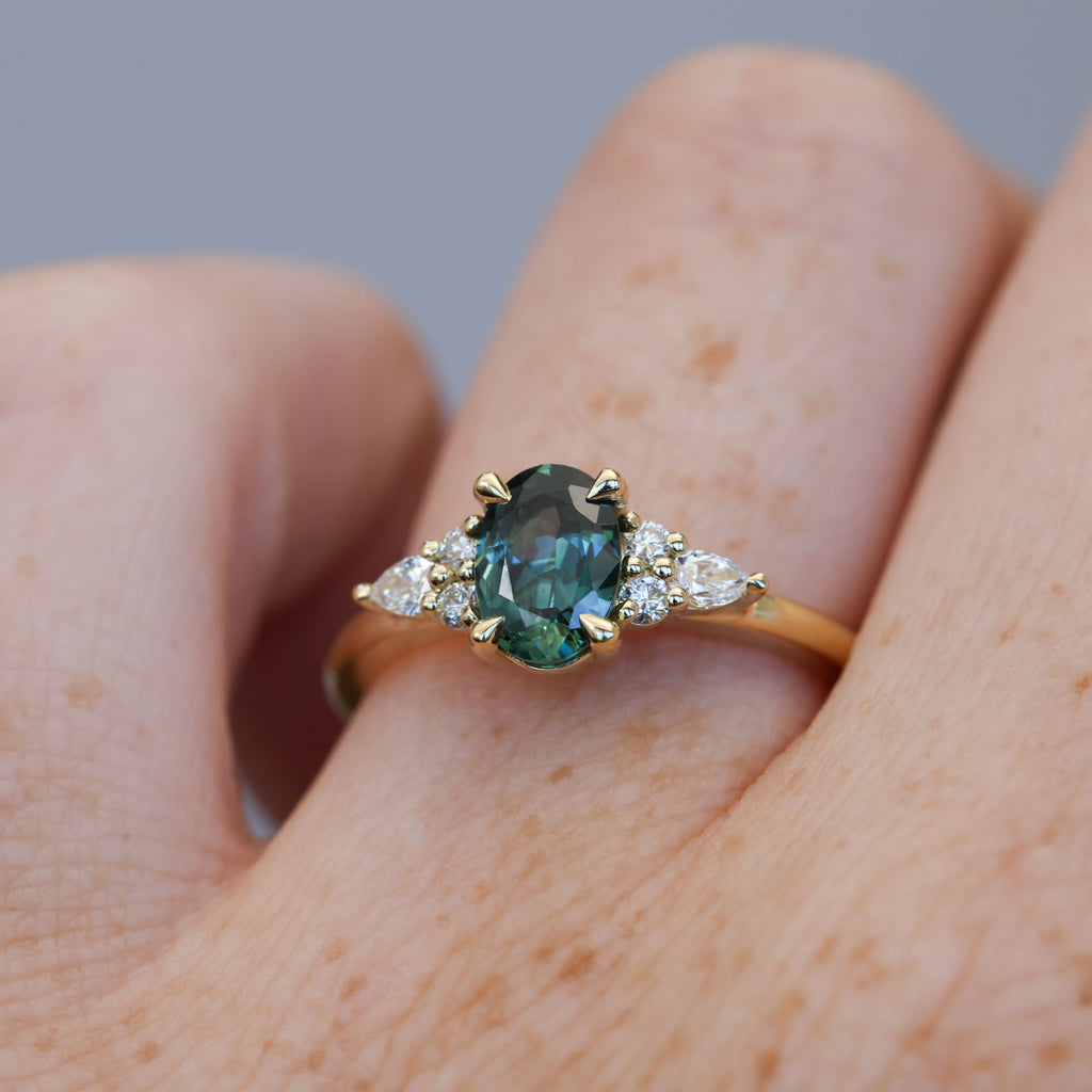 0.93ct oval cut Australian Sapphire and diamond engagement ring in yellow gold on hand