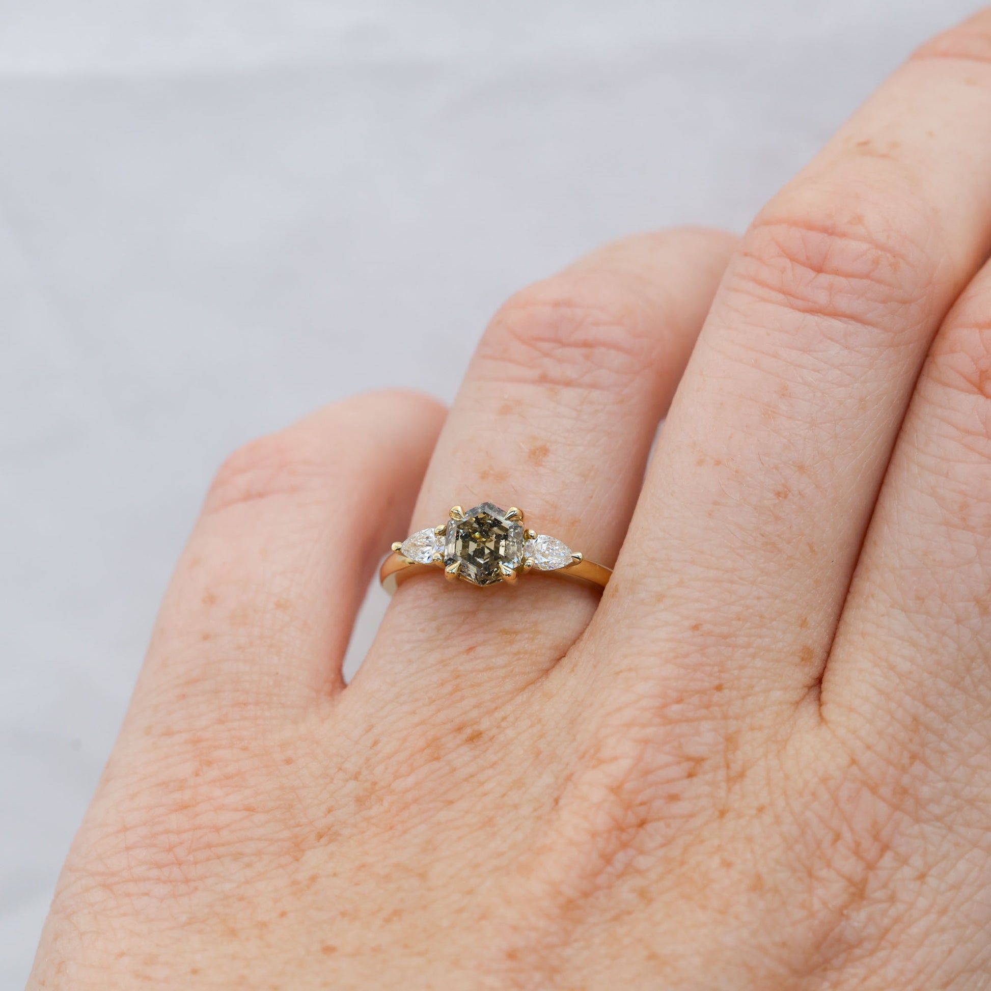 natural hexagon cut salt and pepper champagne diamond trilogy engagement ring yellow gold on hand
