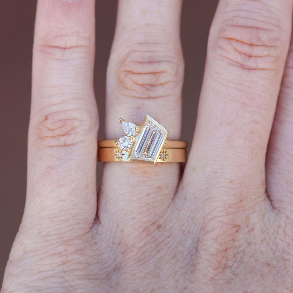 1.02ct asymmetrical trapeze diamond engagement ring on hand with wedding band