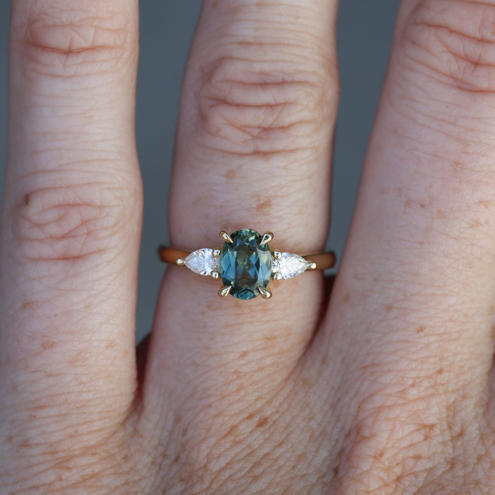 1.11ct oval cut australian sapphire trilogy engagement ring on hand