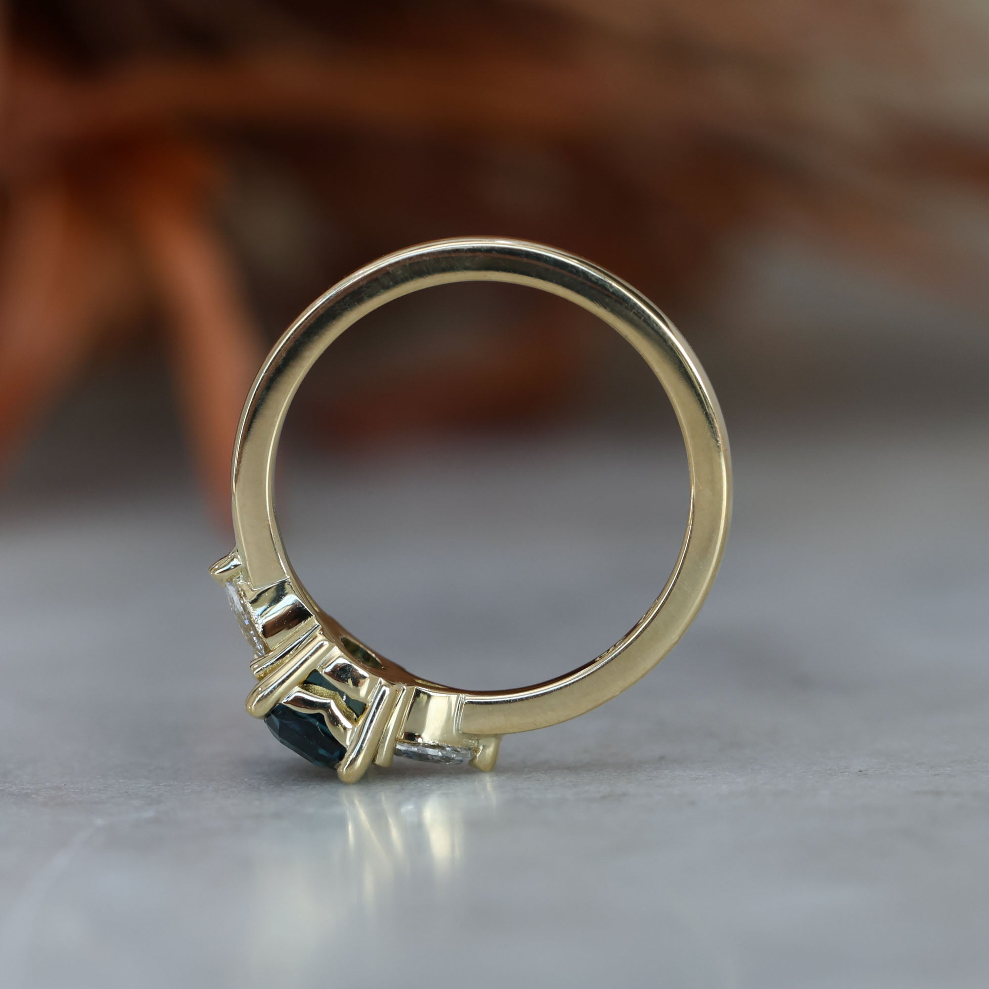 1.13ct emerald cut Madagascan sapphire trilogy engagement ring profile view