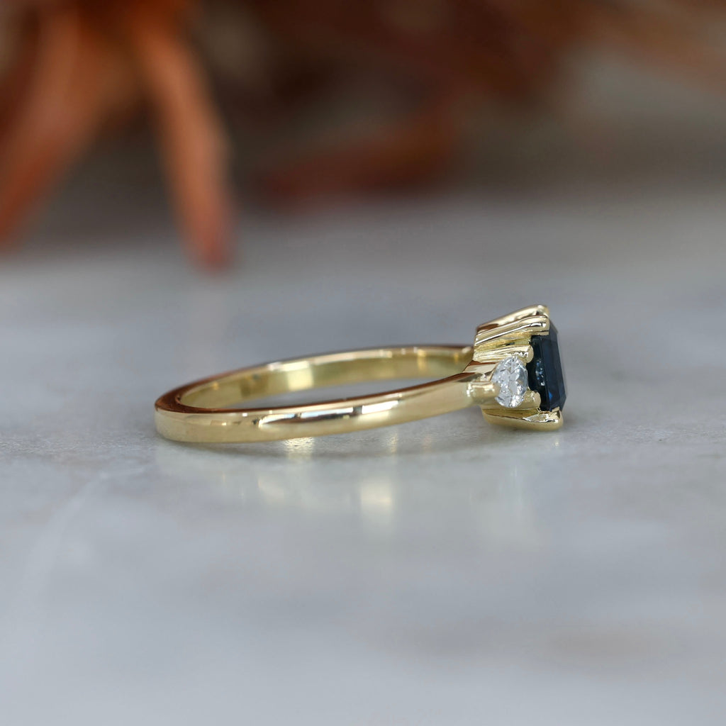 1.13ct emerald cut Madagascan sapphire trilogy engagement ring side view