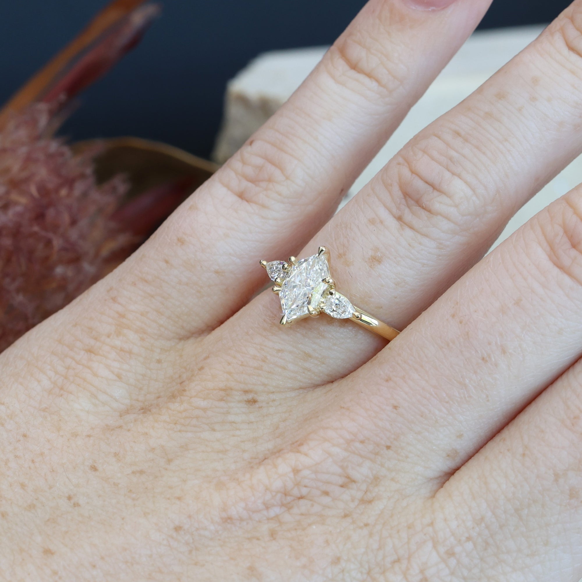 1.15ct Elongated Hexagon Diamond trilogy engagement ring on hand