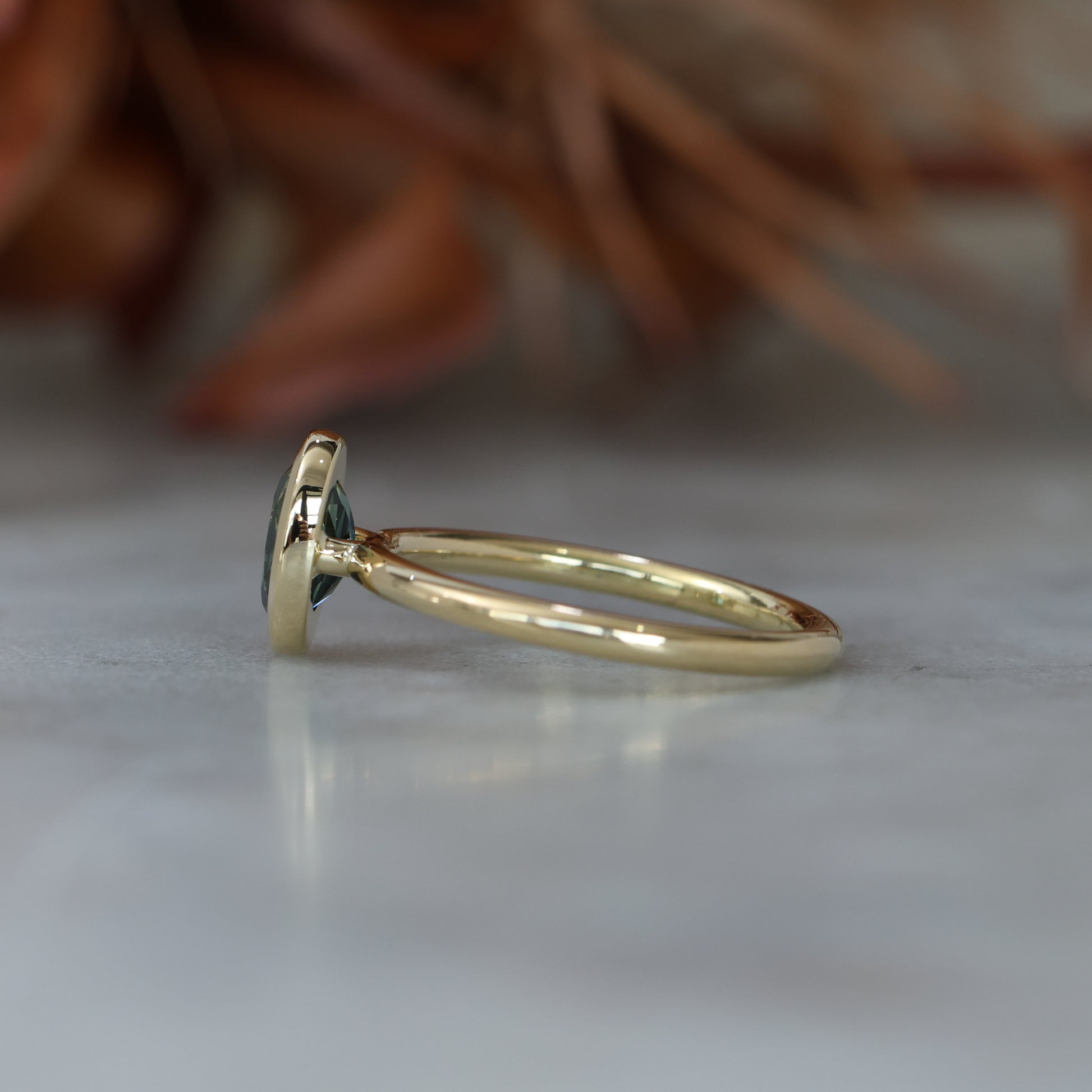 Bezel set oval cut Australian parti sapphire engagement ring in 18ct yellow gold