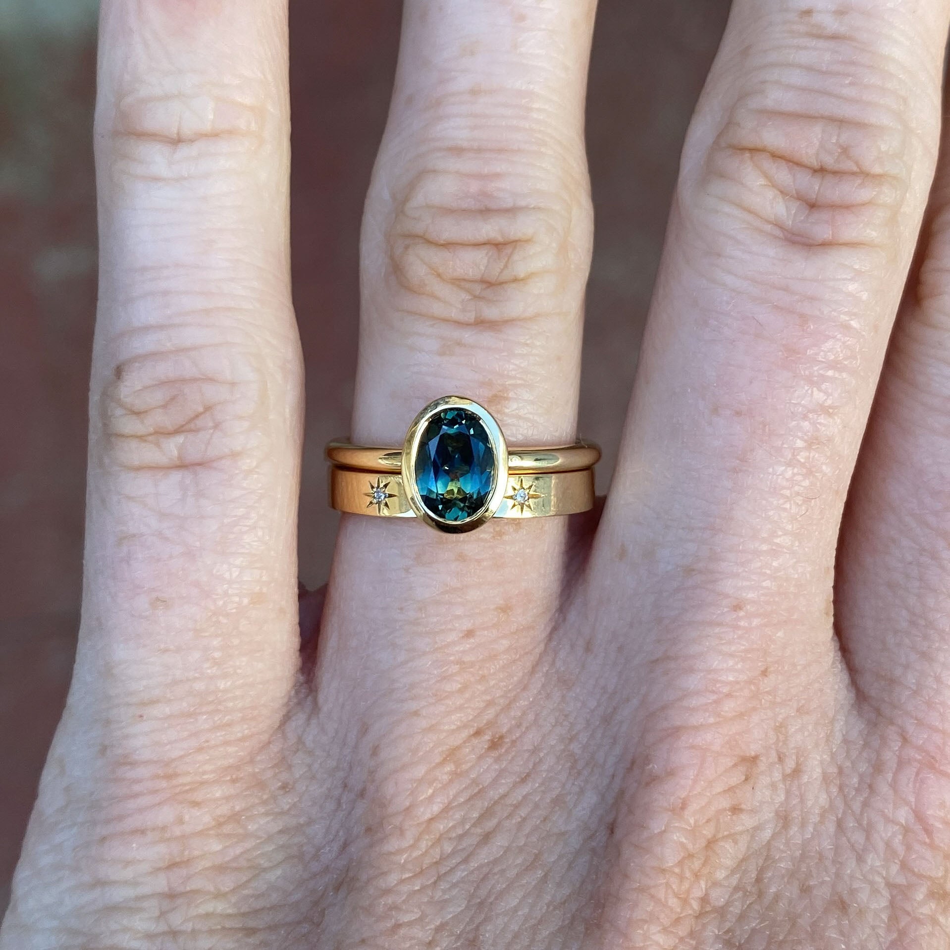 1.19ct oval cut australian parti sapphire bezel engagement ring on hand