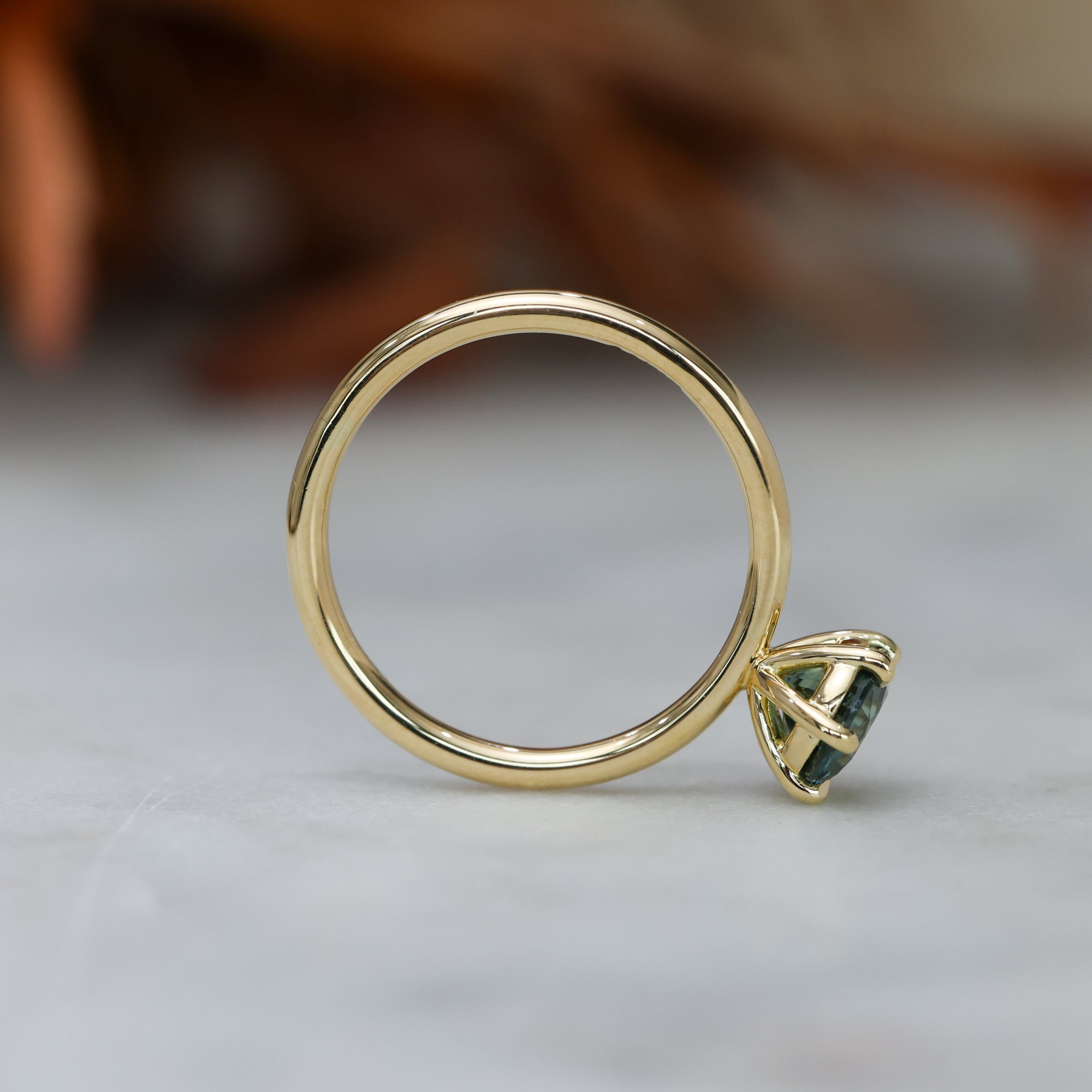 1.20ct round cut madagascan sapphire solitaire engagement ring, set in 18ct yellow gold profile setting view