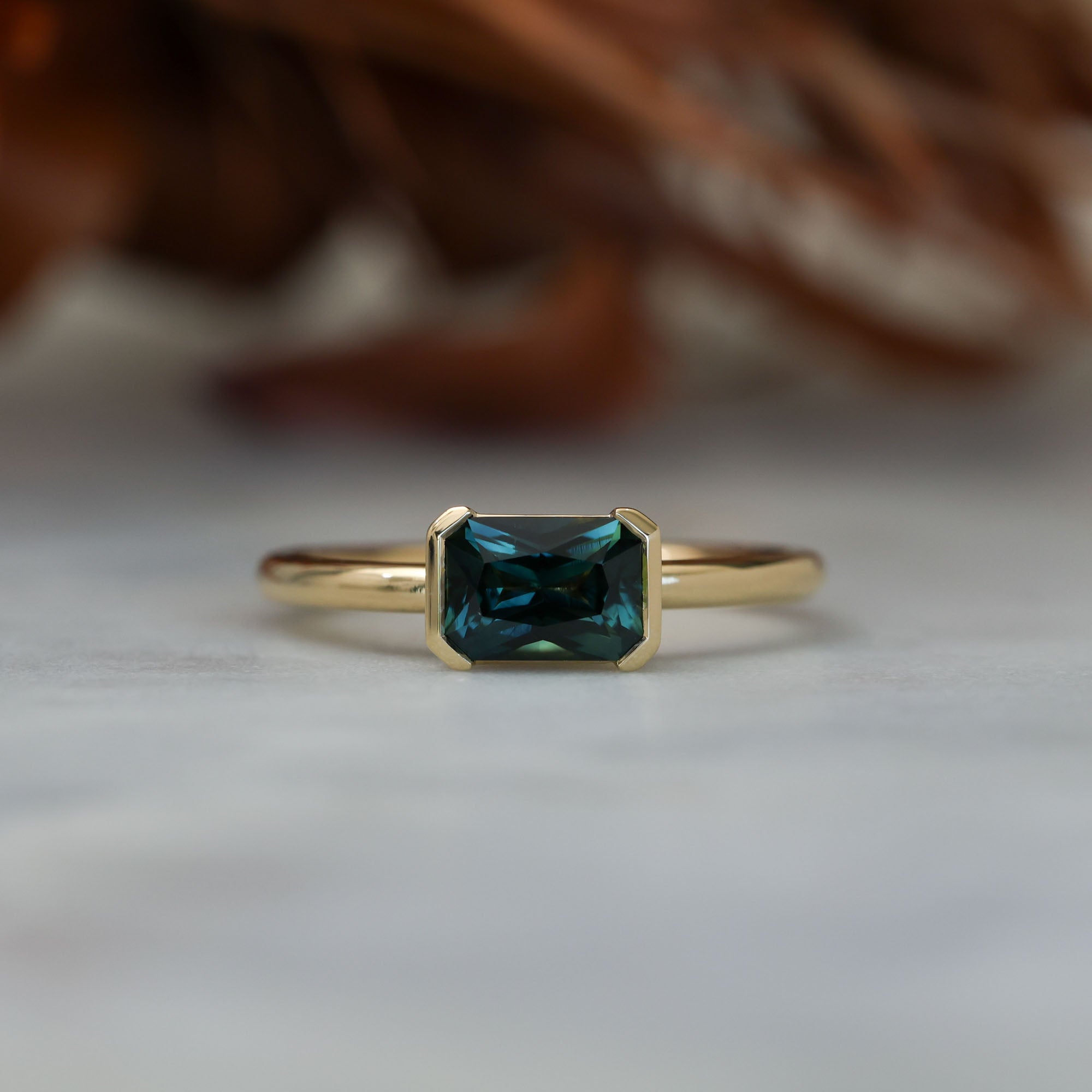 1.20ct emerald cut australian parti saphire east west semi bezel engagement ring