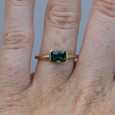 1.20ct emerald cut australian parti saphire east west semi bezel engagement ring on hand