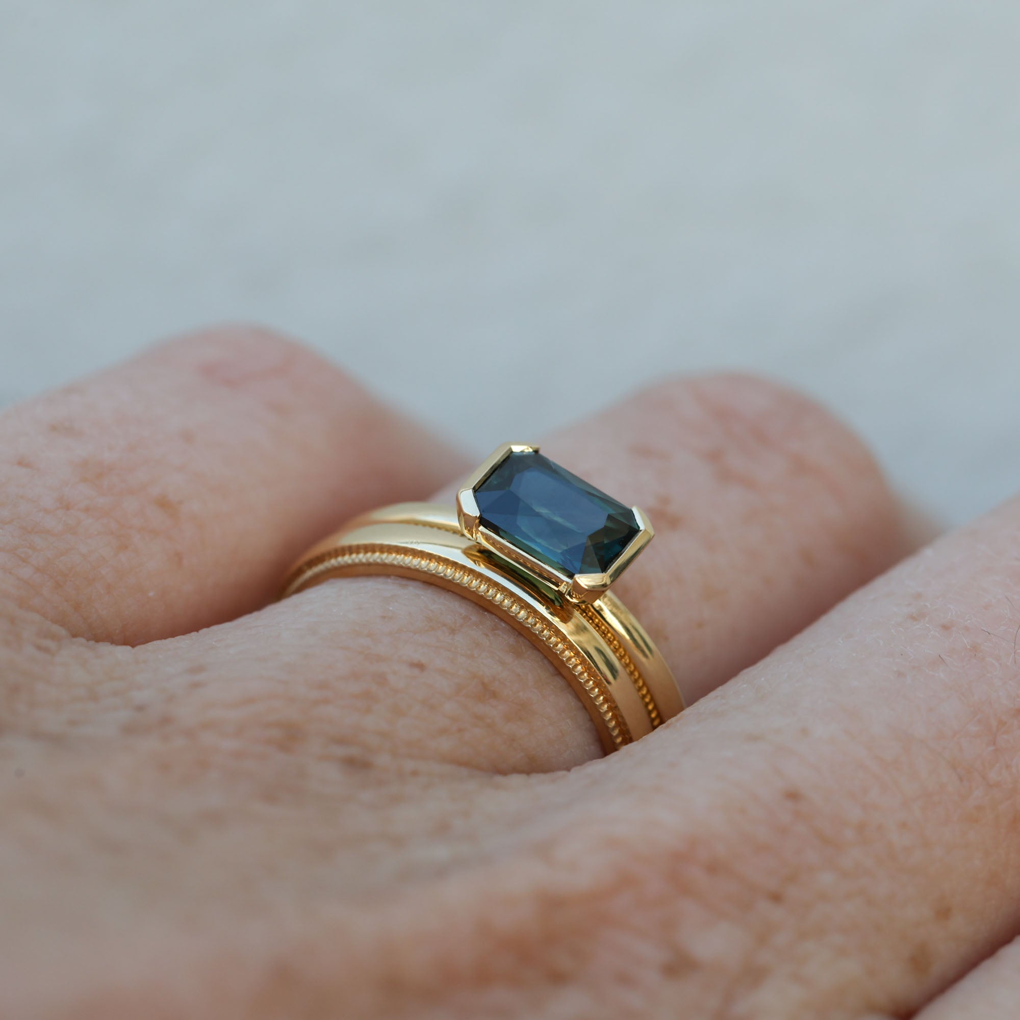 1.20ct emerald cut australian parti saphire east west semi bezel engagement ring profile with wedding band