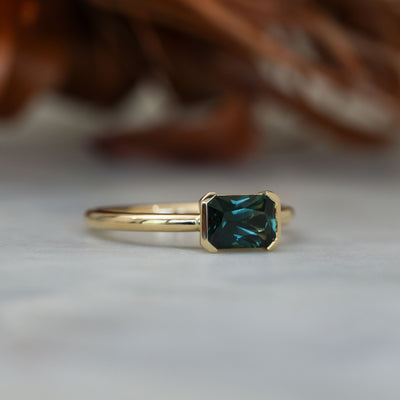 1.20ct emerald cut australian parti saphire east west semi bezel engagement ring side