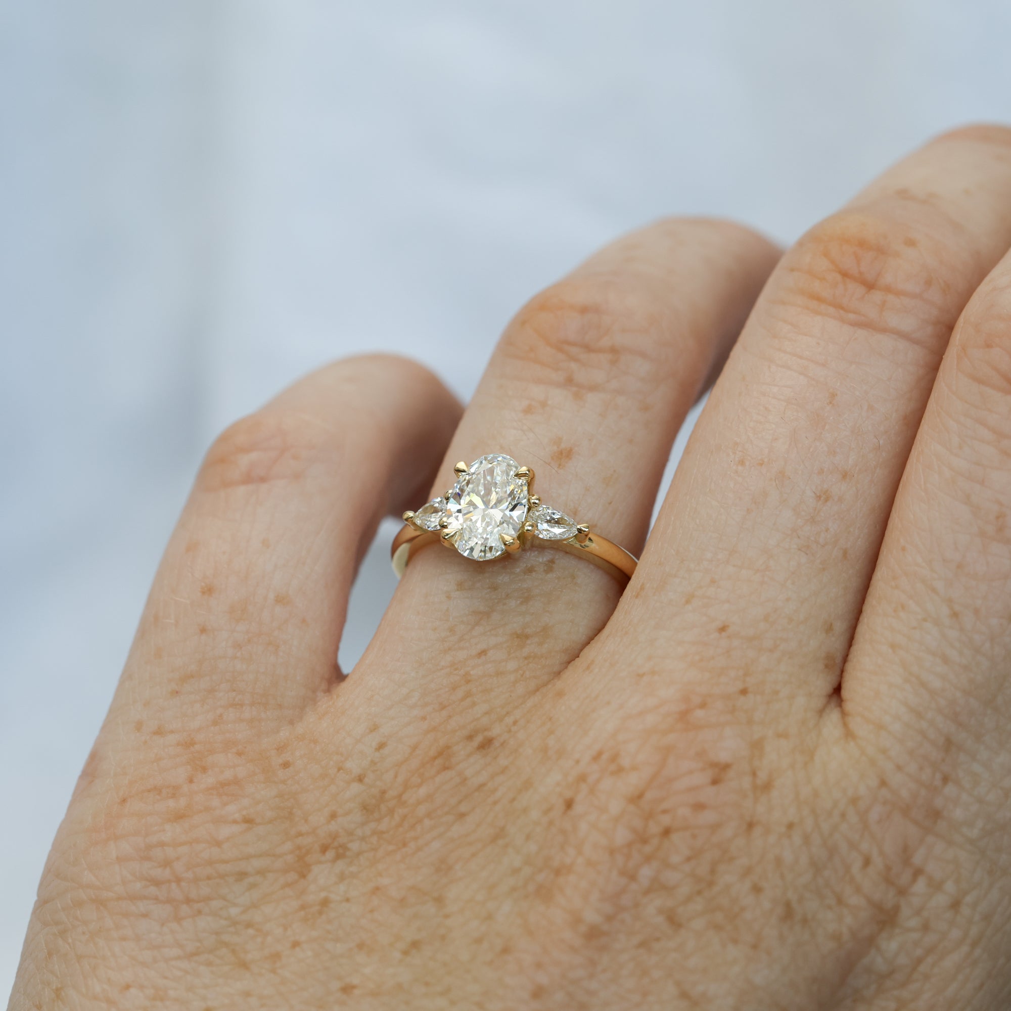 1.25ct oval cut diamond may trilogy engagement ring on hand