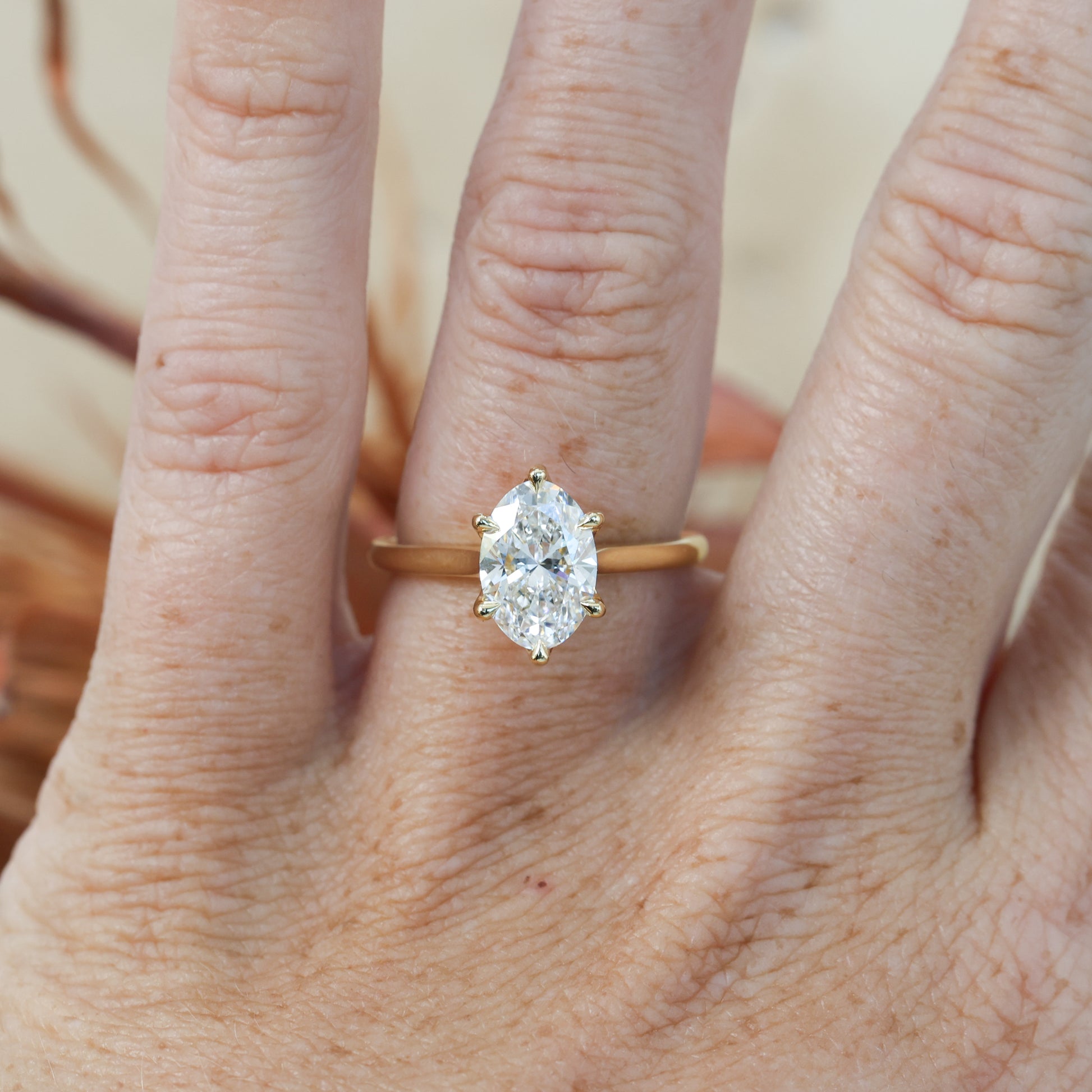 2ct oval cut diamond solitaire engagement ring on hand