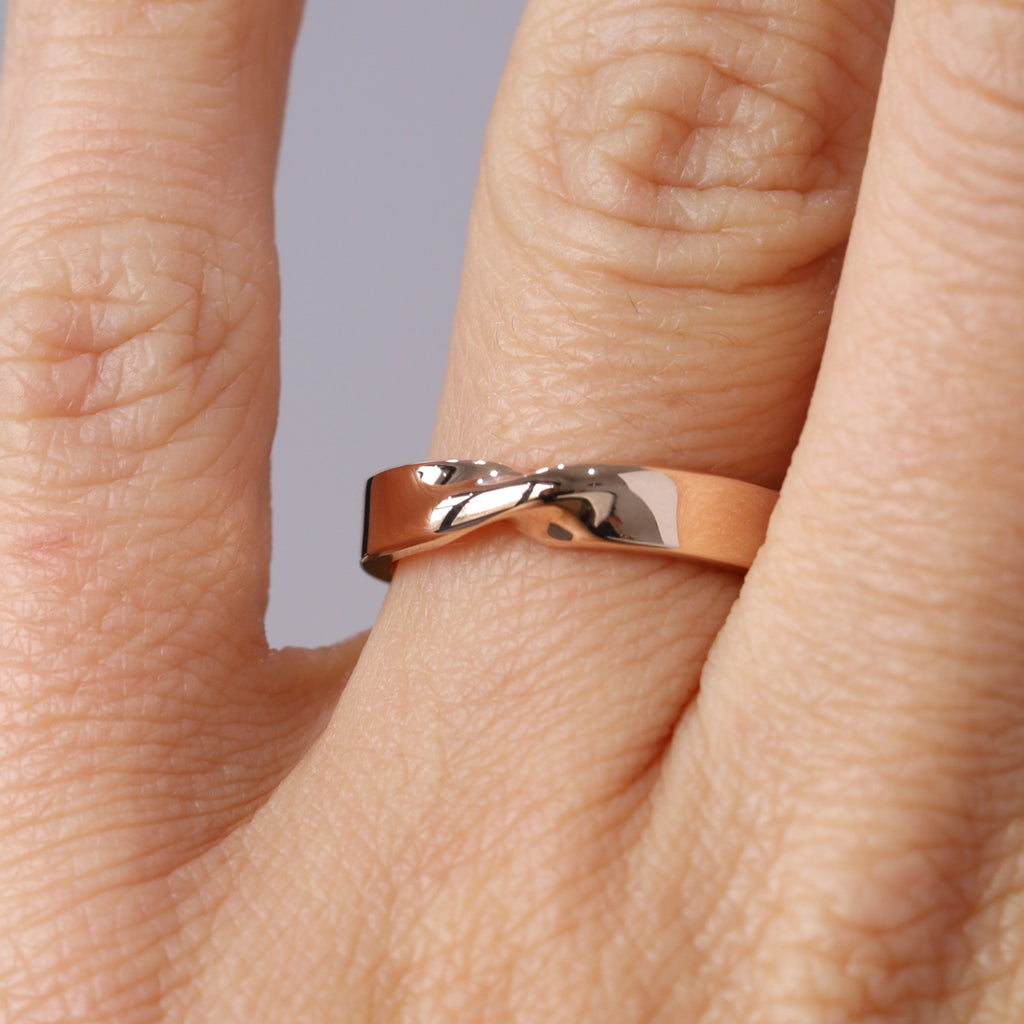 4mm gold mobius twist wedding band on hand