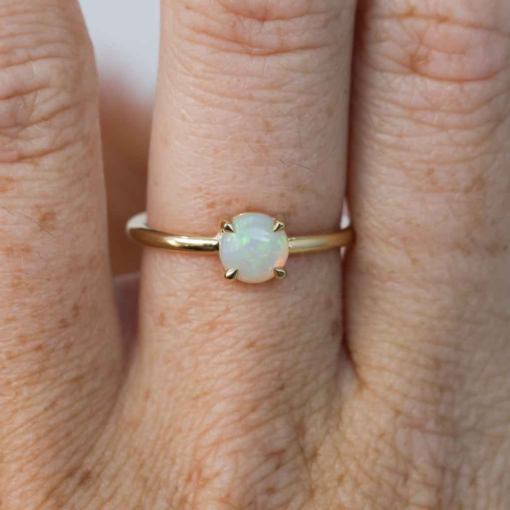 6mm round cut Australian opal ring yellow gold on hand