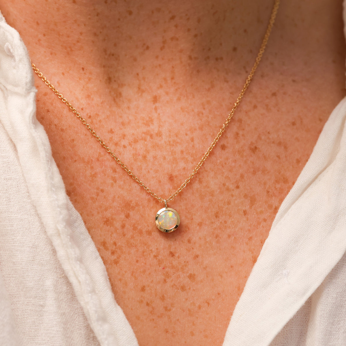 round cut opal set in a full 9ct yellow gold bezel east west setting