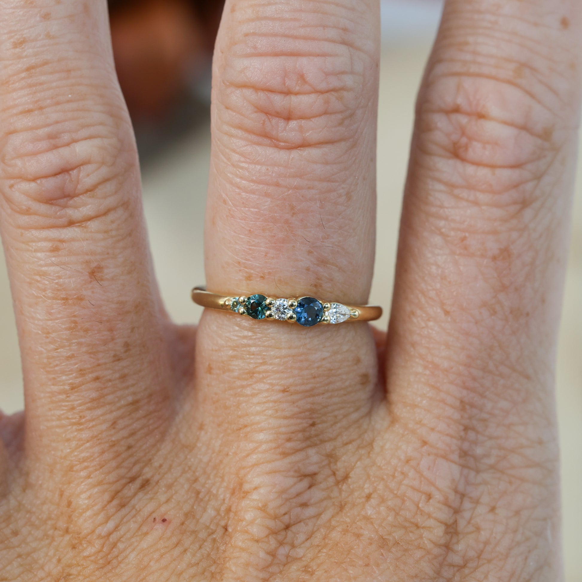 Blue and green Australian Sapphire and diamond fine jewellery ring yellow gold on hand