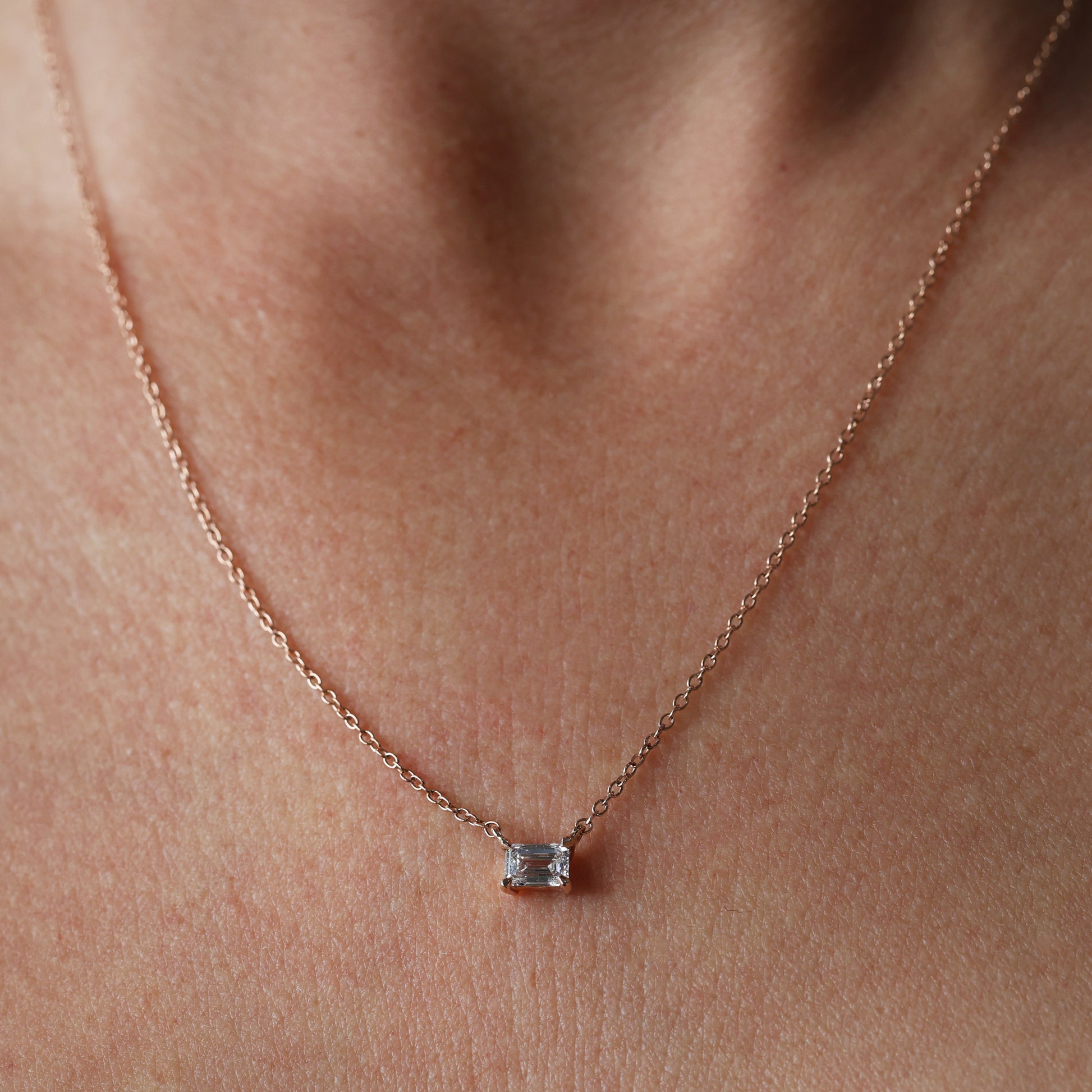 Emerald cut diamond necklace on neck