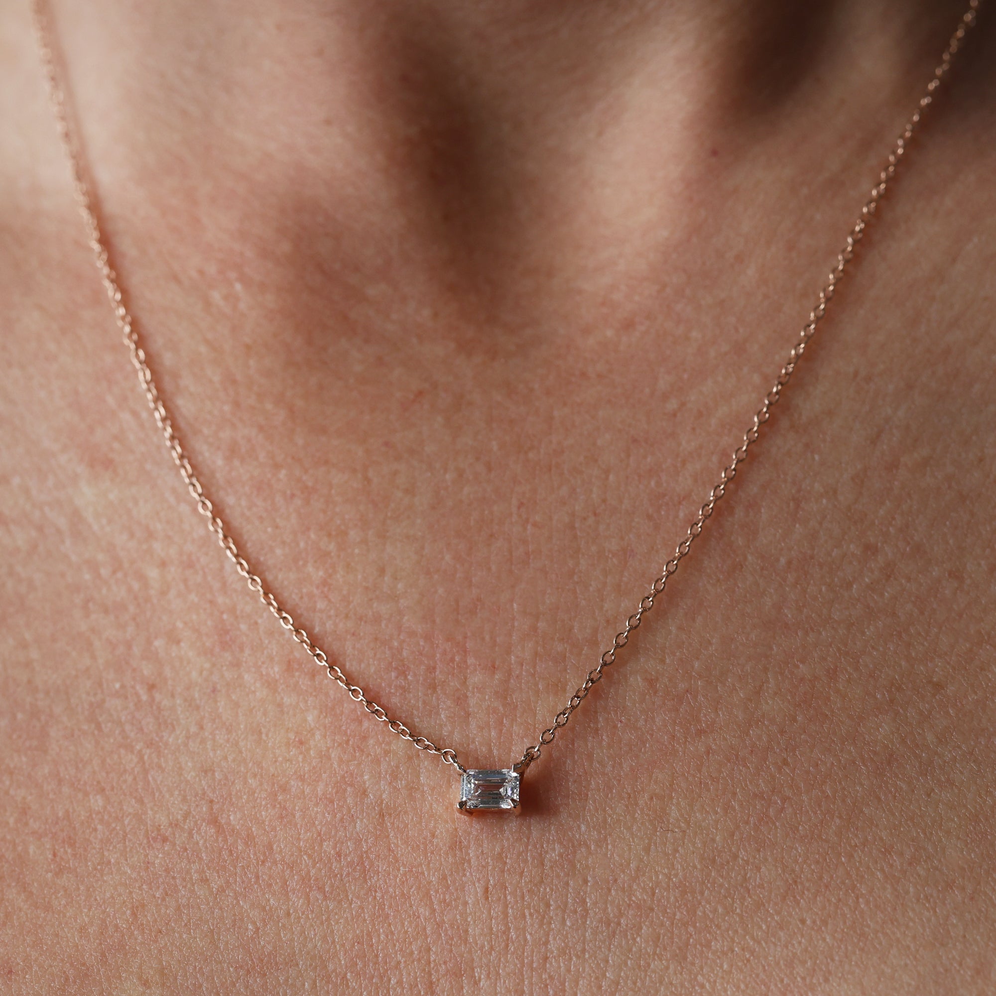 Emerald cut diamond necklace on neck