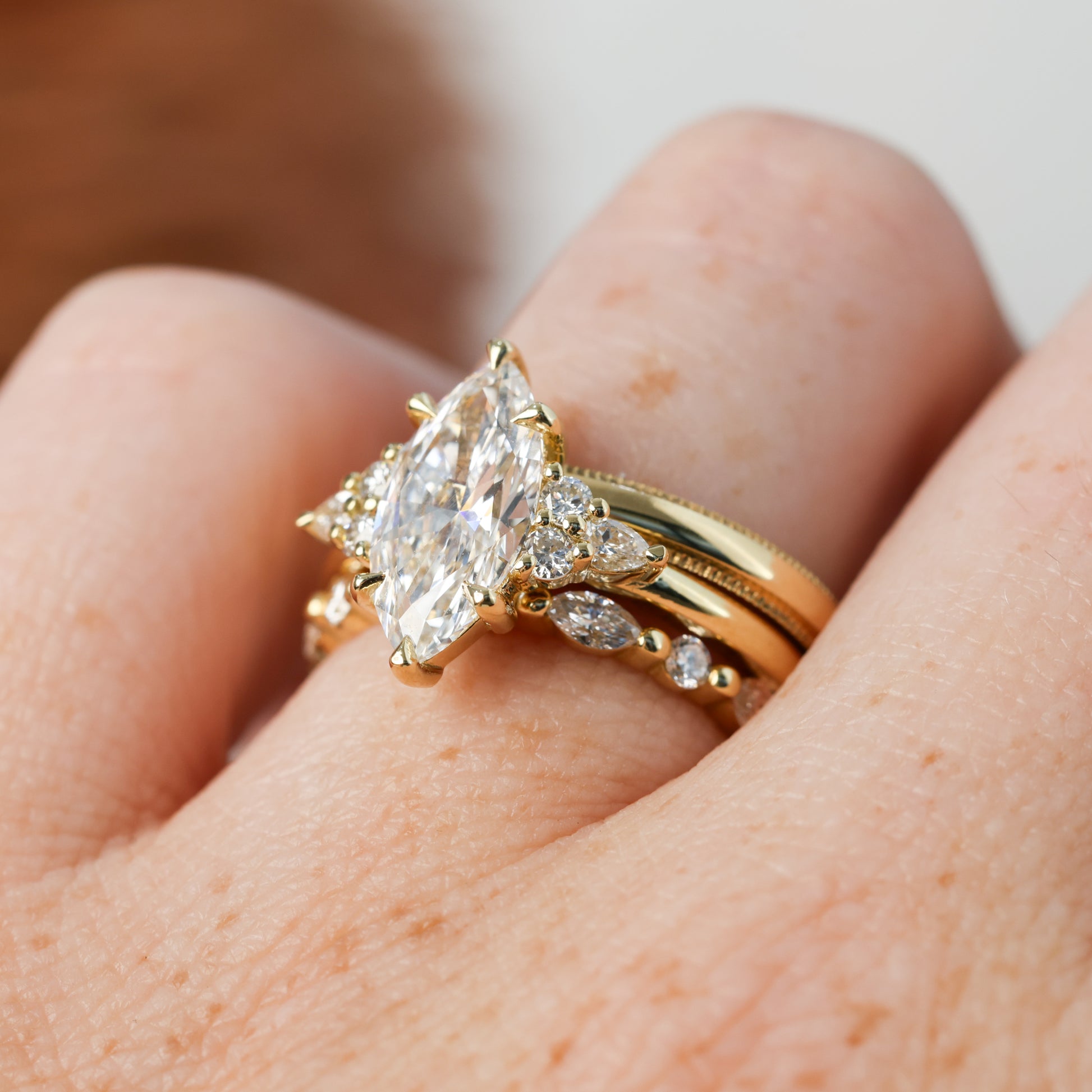 2.01ct marquise cut diamond engagement ring, crafted in yellow gold with wedding band on hand