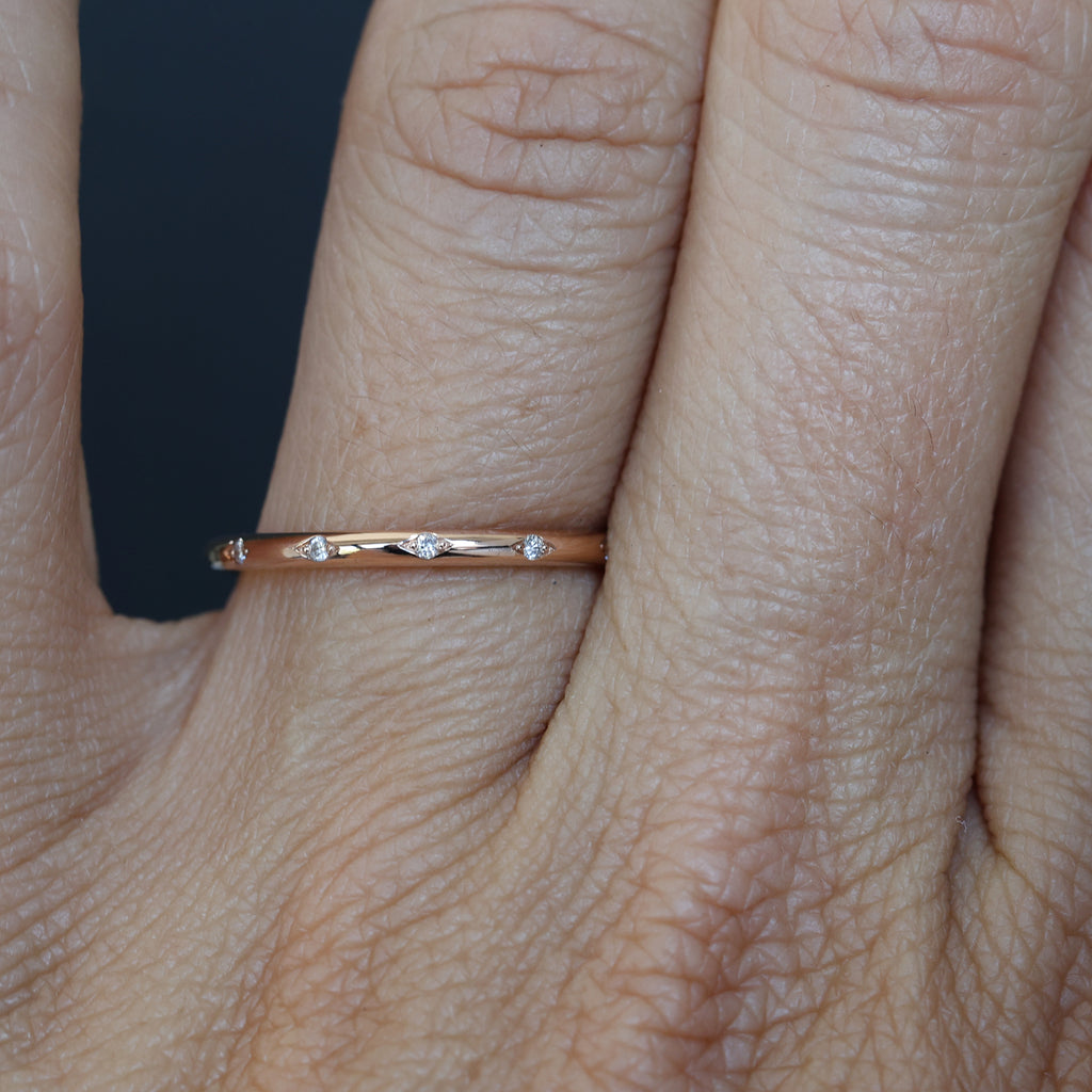 Flat diamond wedding band with diamond star details on hand