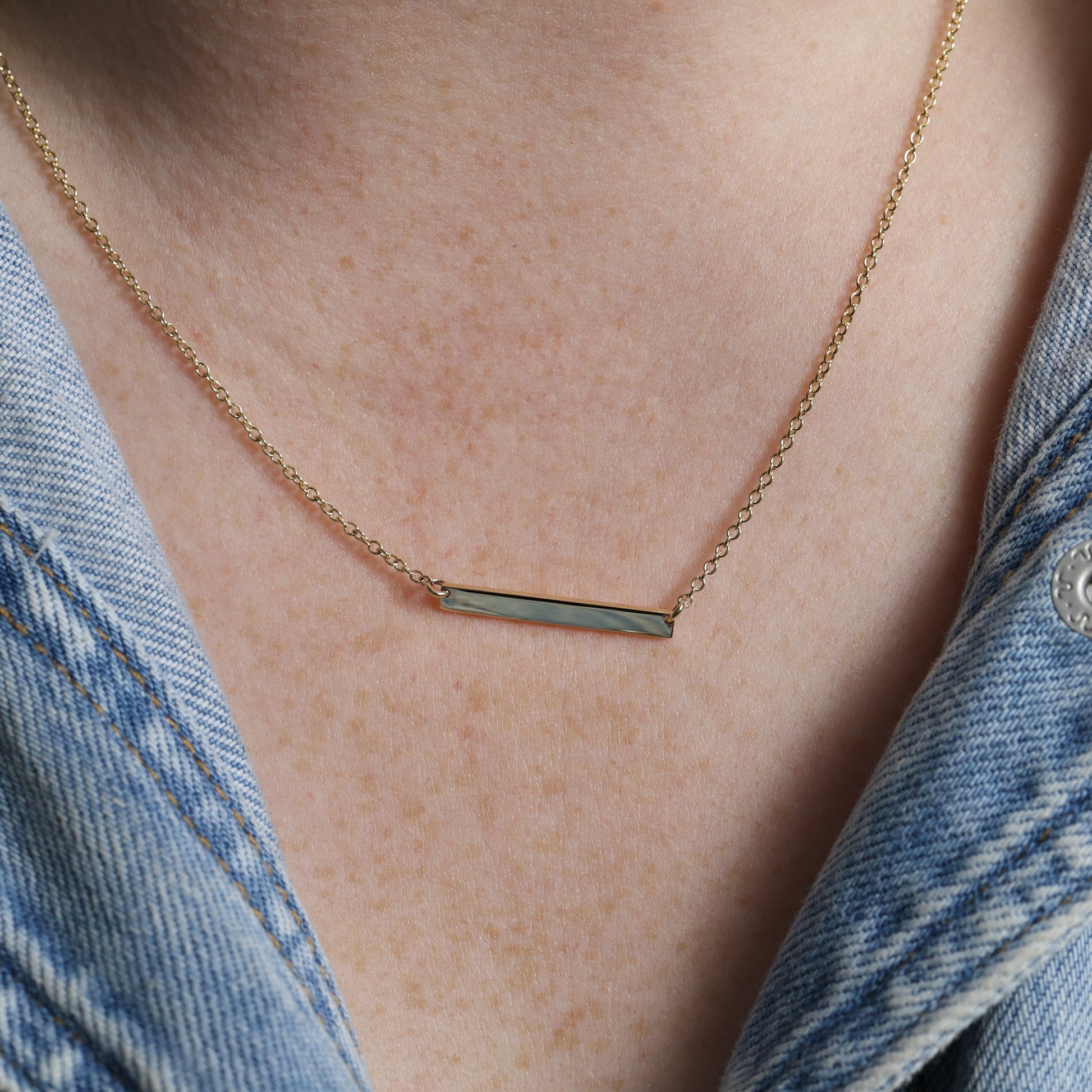 Gold bar necklace on neck 1