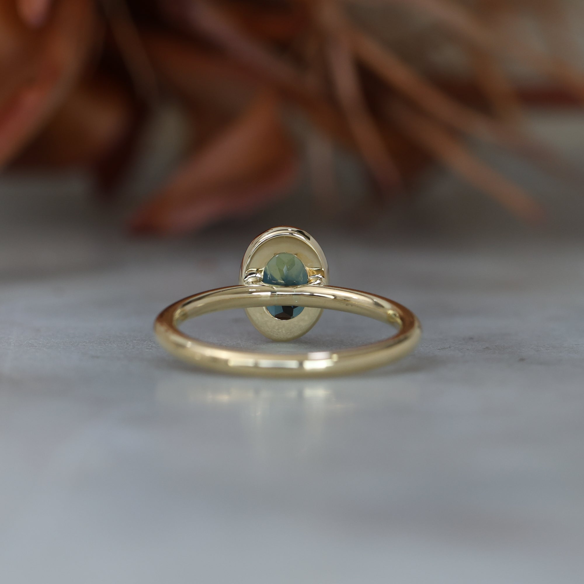 Bezel set oval cut Australian parti sapphire engagement ring in 18ct yellow gold  back view