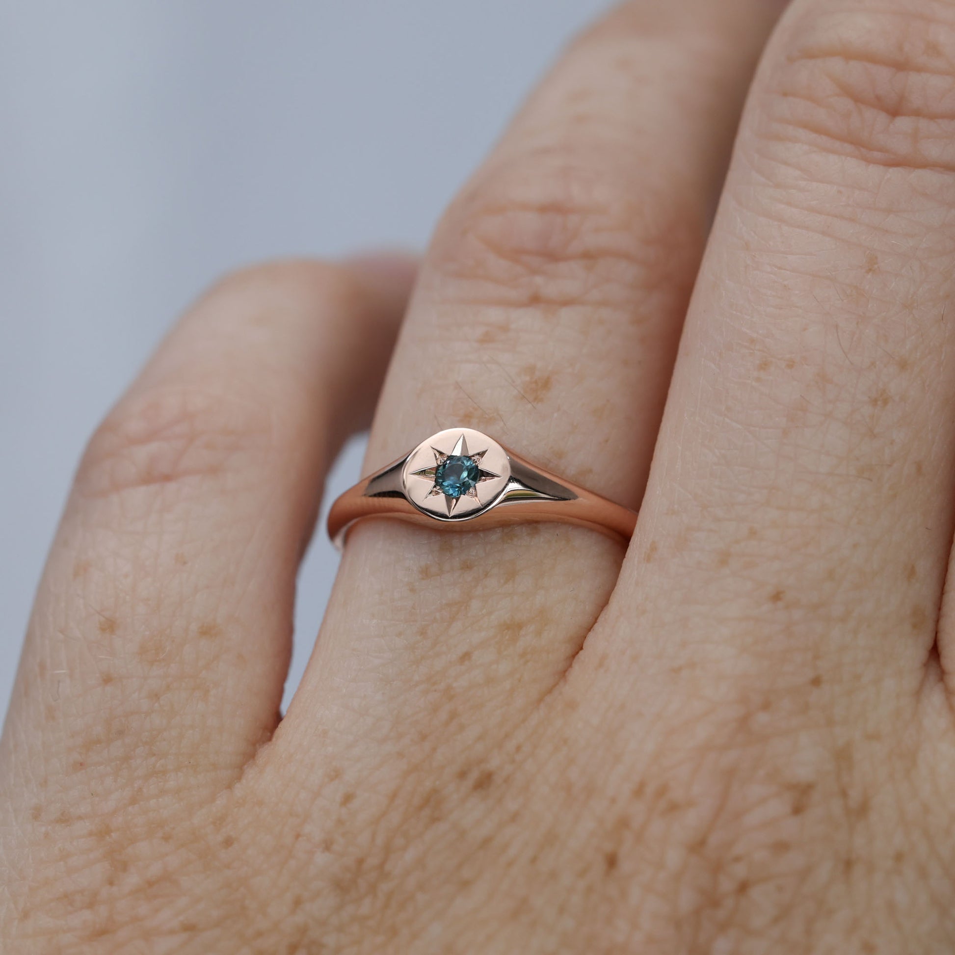 round star set australian sapphire signet ring in rose gold on hand