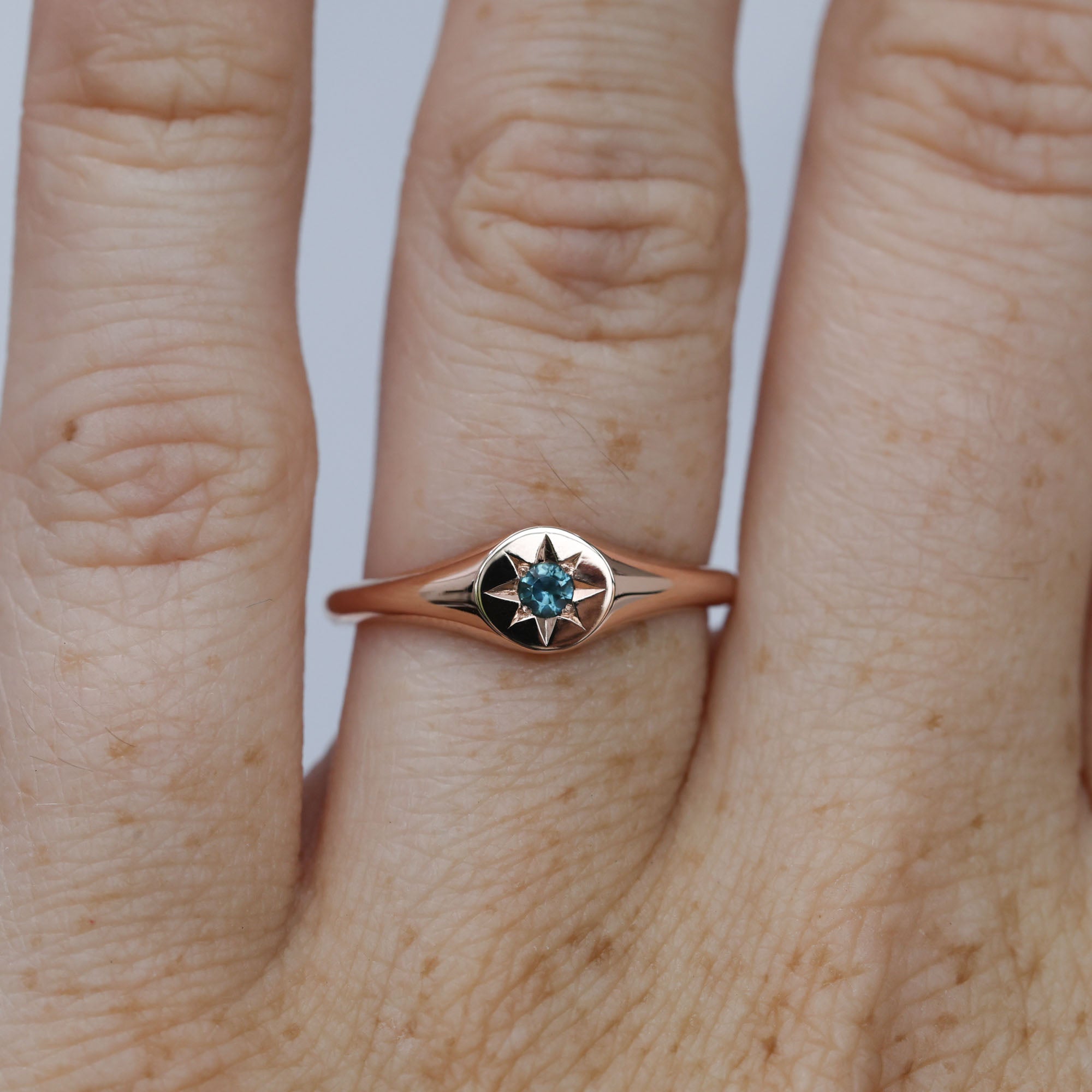 round star set australian sapphire signet ring in rose gold on hand