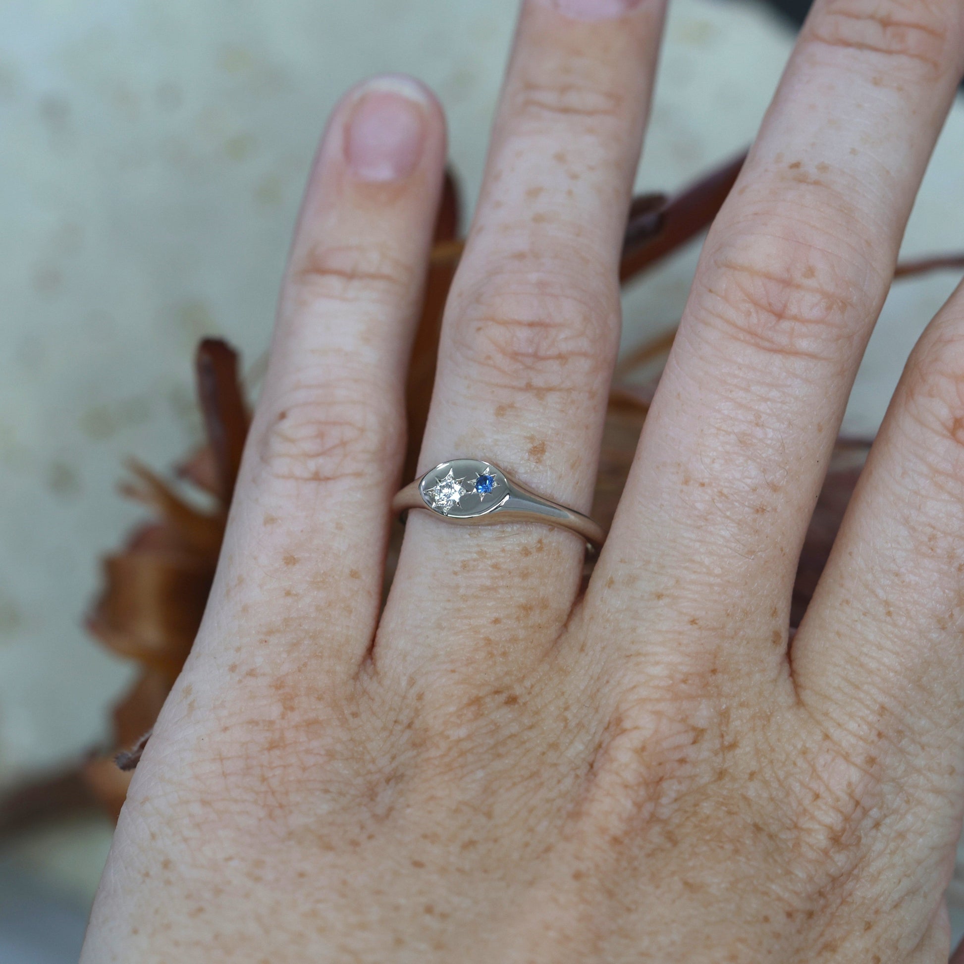 White Gold Star Set Sapphire and Diamond Signet Ring on hand